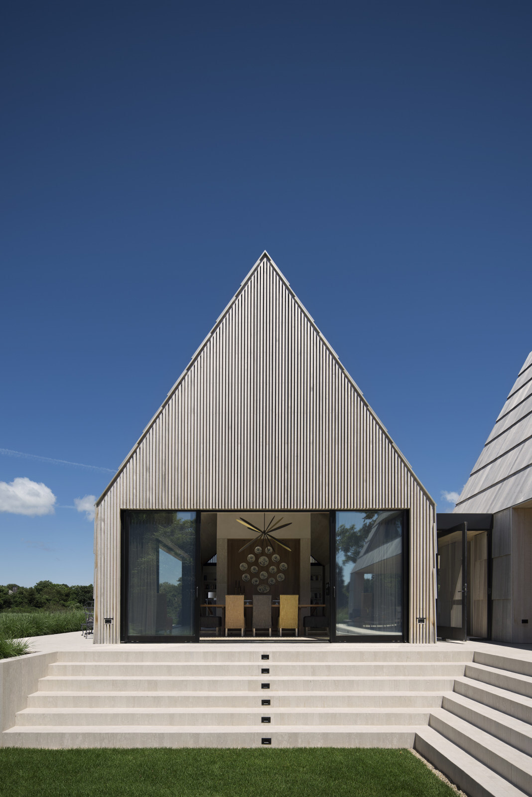 Las tejas de cedro de gran tamaño y las elegantes mamparas de cedro le dan a esta casa costera un aspecto cálido y texturizado.