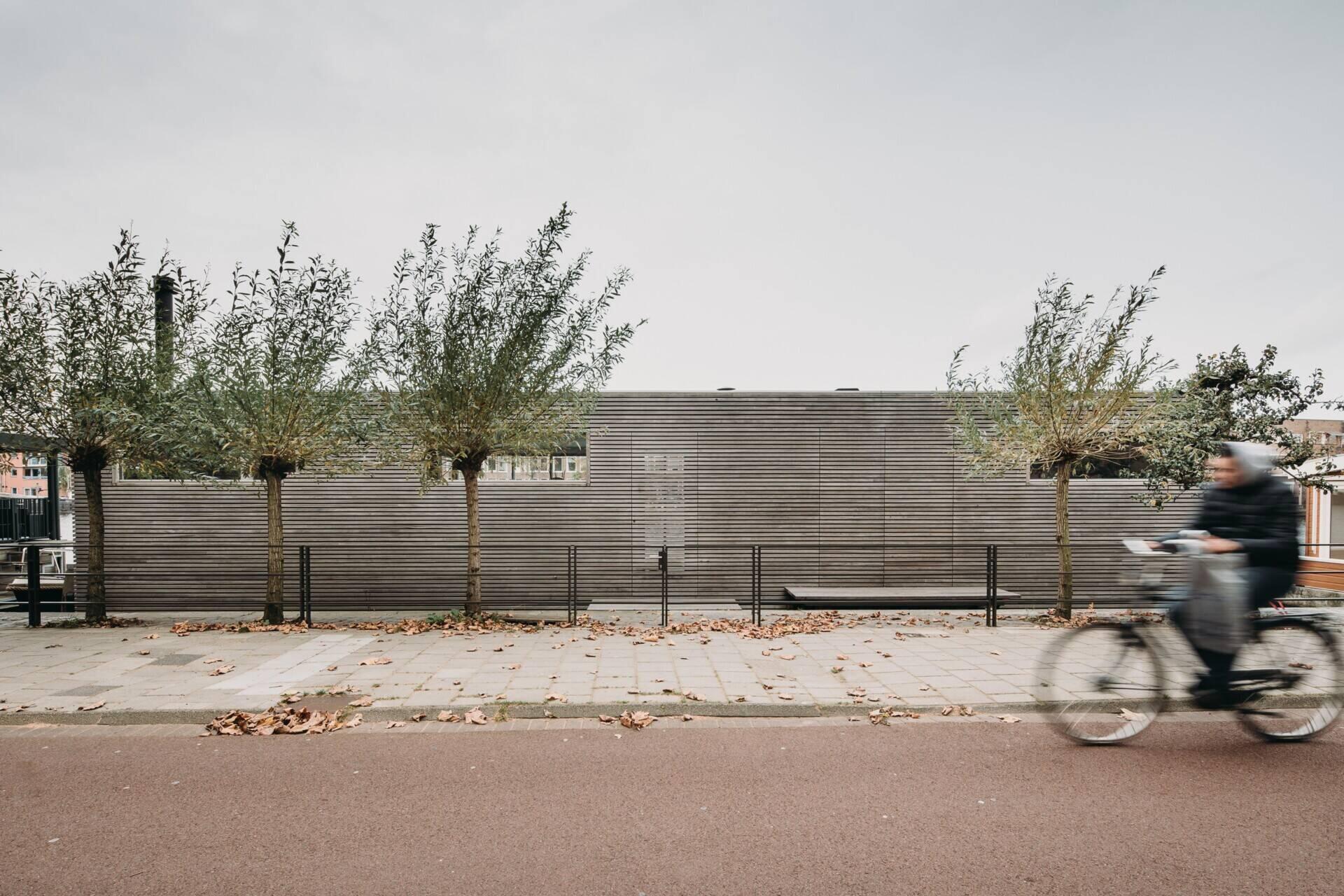 Una sorprendente villa flotante en Spaarne, con revestimientos de madera texturizada, finas molduras de aluminio y una brillante luz del suroeste dan forma al diseño.
