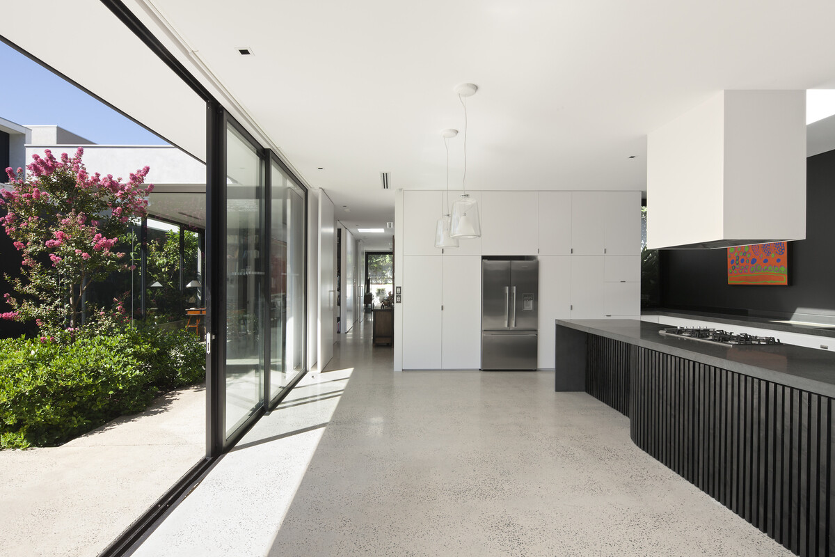 In this kitchen, full height windows at the rear of the home connect the kitchen to the terraced garden beds outside