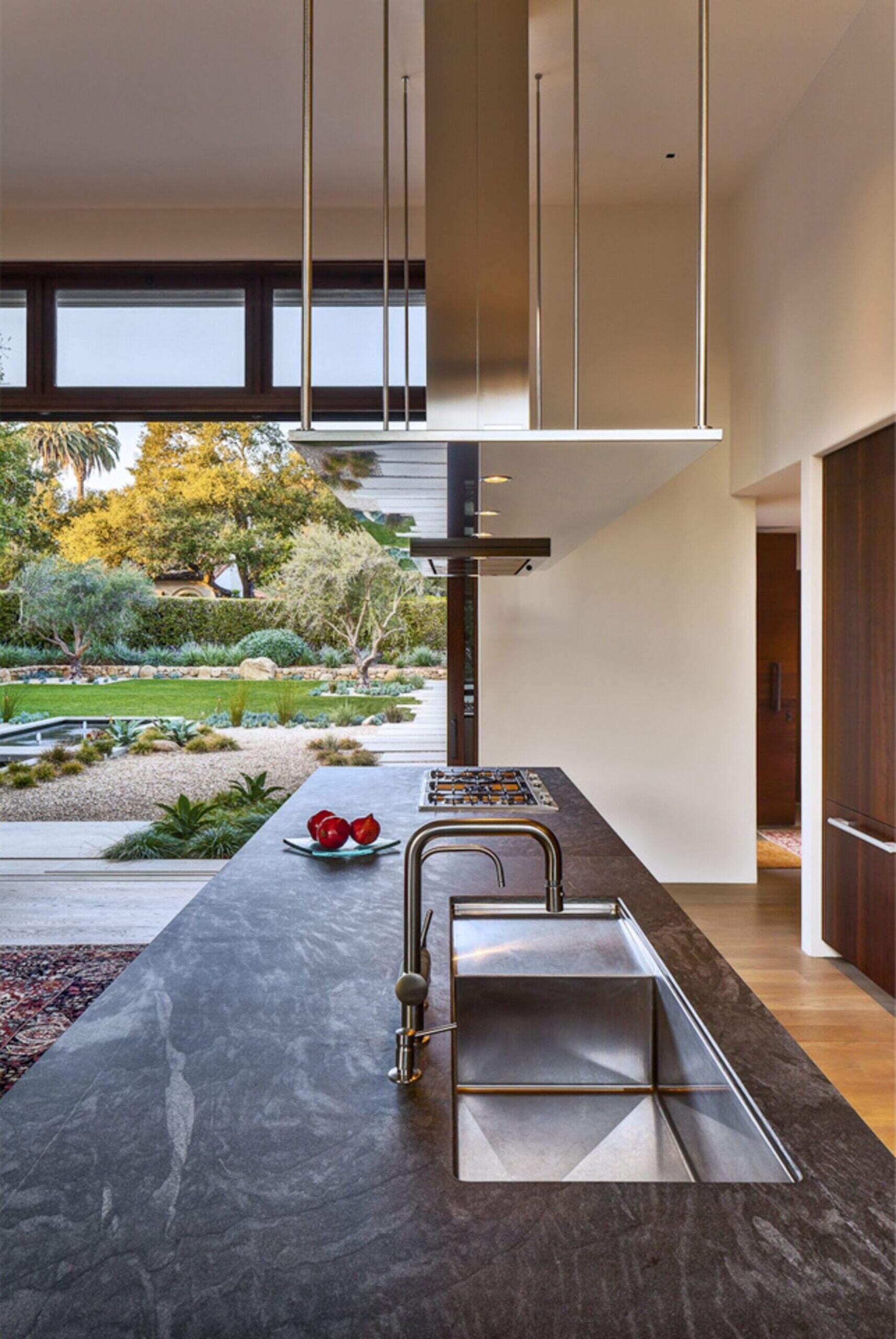 A minimalist Montecito kitchen with soapstone counters, wood cabinetry, and stainless details.