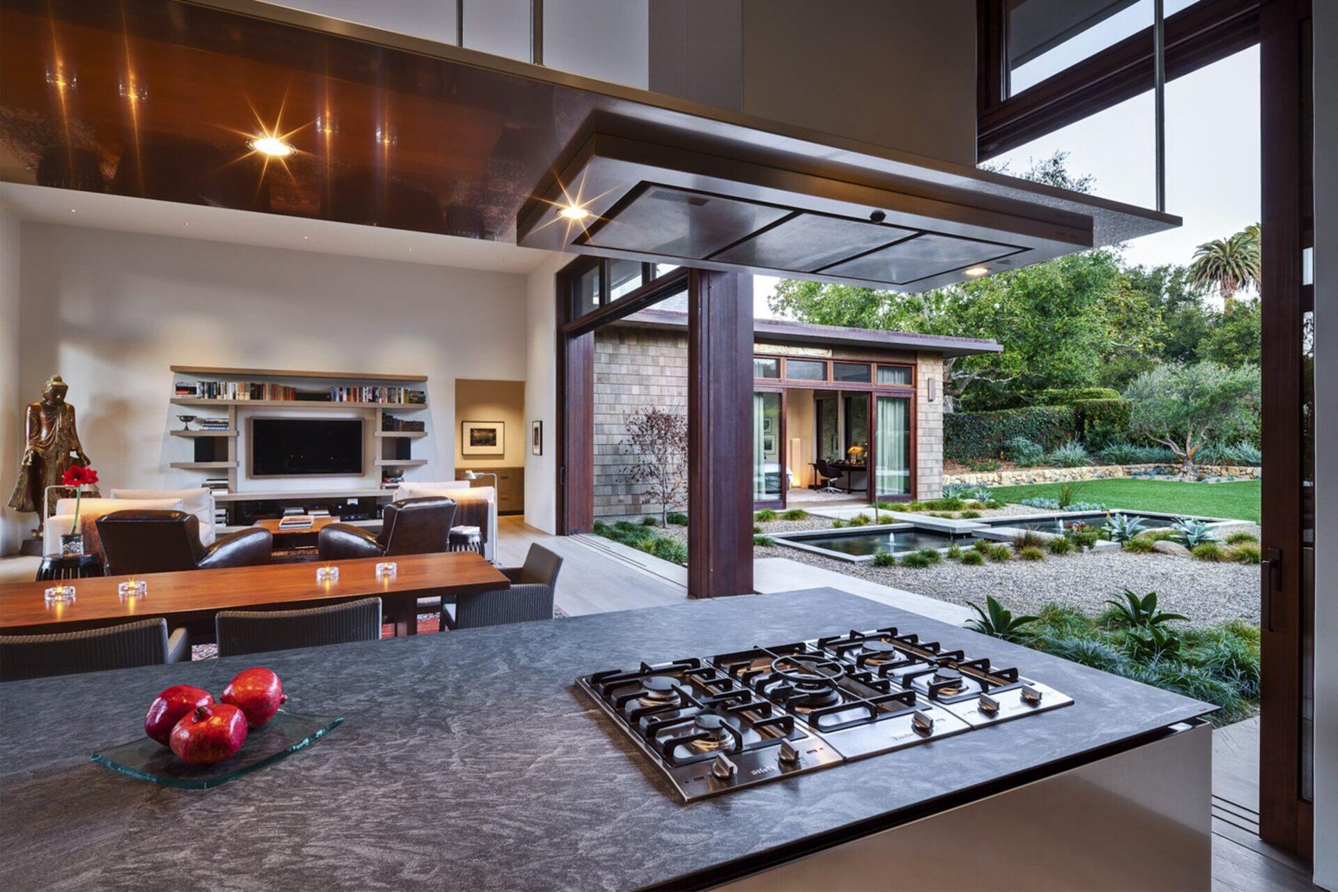 A minimalist Montecito kitchen with soapstone counters, wood cabinetry, and stainless details.