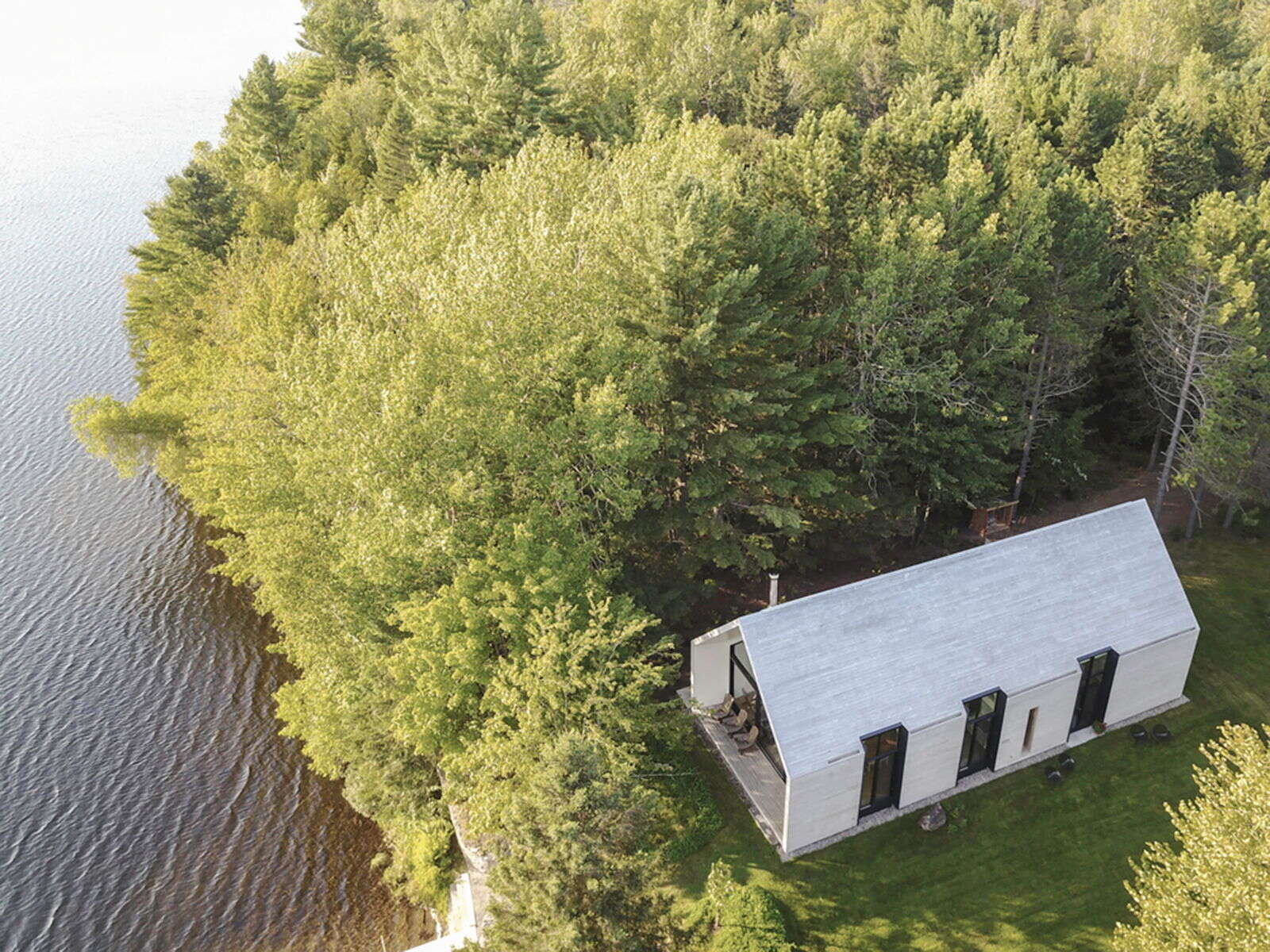 Una tranquila cabaña de cedro en Quebec, ubicada en un claro del bosque, ofrece un enfoque simple y tranquilo para vivir junto al lago.