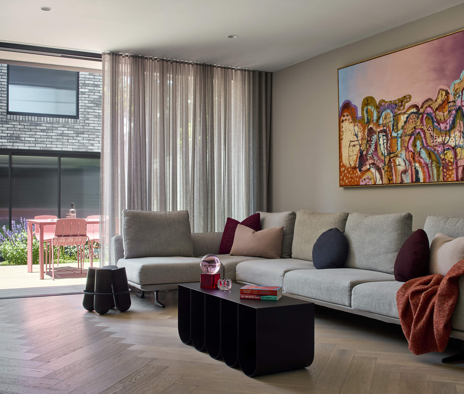 The living room benefits from a wide opening, gaining fresh air, views, and a strong link to the terrace and garden.