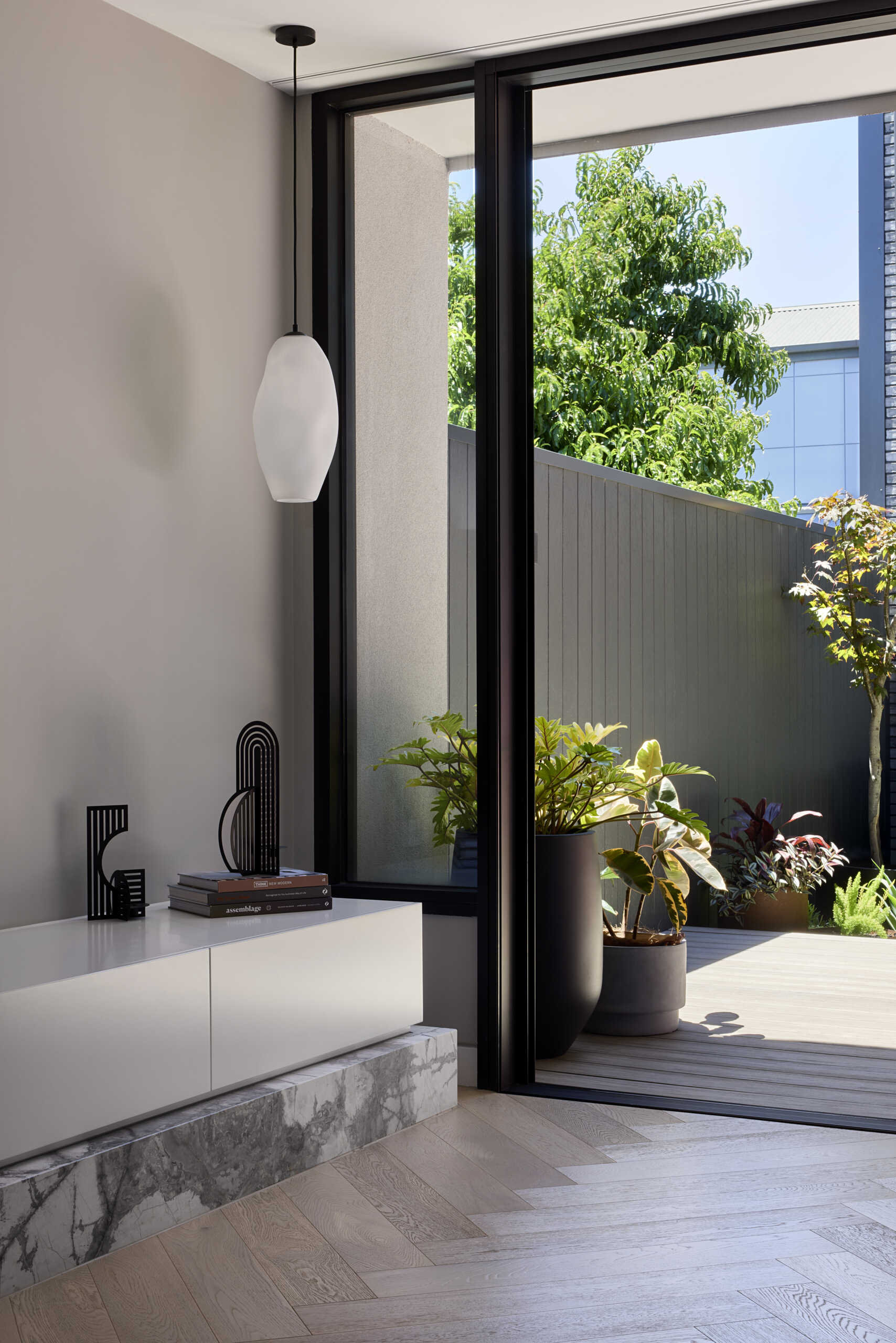 The living room benefits from a wide opening, gaining fresh air, views, and a strong link to the terrace and garden.