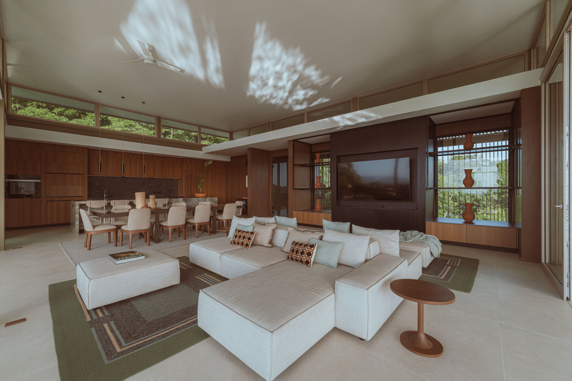 The main social spaces are placed on the upper level to capture ocean views and natural ventilation. The living room, with its double-sided couch, opens in multiple directions and feels integrated with the planted terrace and cantilevered pool. 