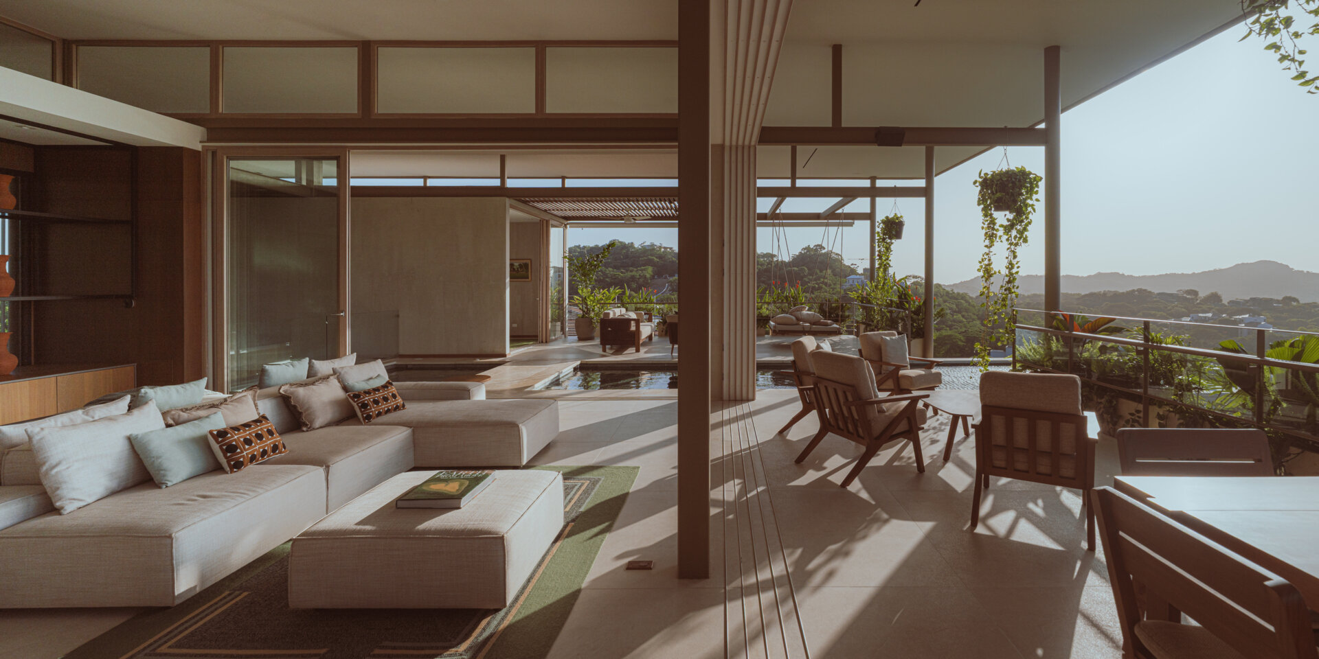 The main social spaces are placed on the upper level to capture ocean views and natural ventilation. The living room, with its double-sided couch, opens in multiple directions and feels integrated with the planted terrace and cantilevered pool. 
