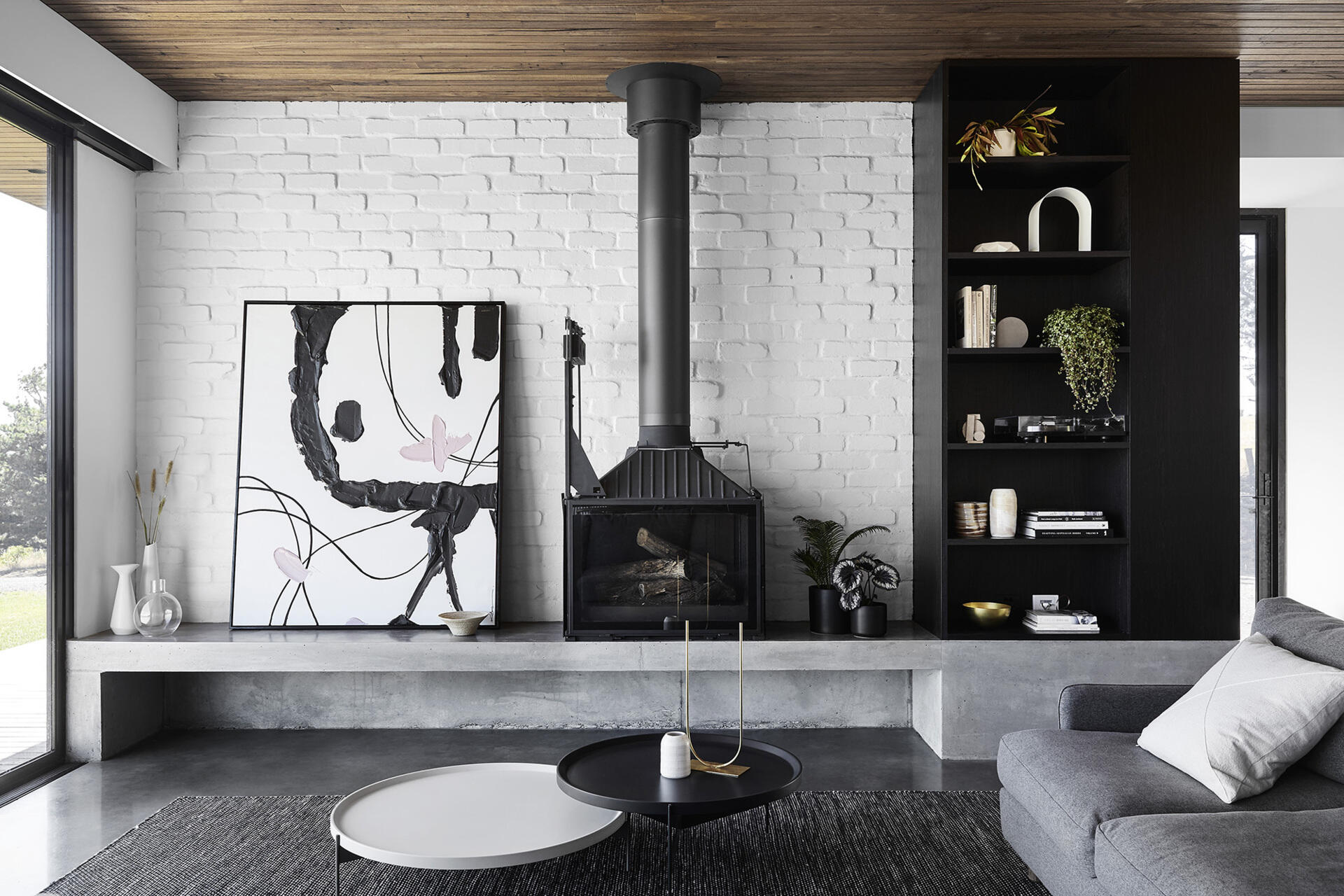 A modern living room with a concrete ledge that acts as a hearth for the fireplace.