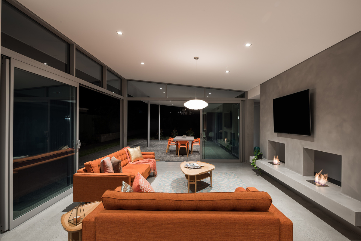 An airy living space with two fireplaces that connects effortlessly to the outdoors, perfect for relaxed Australian living.