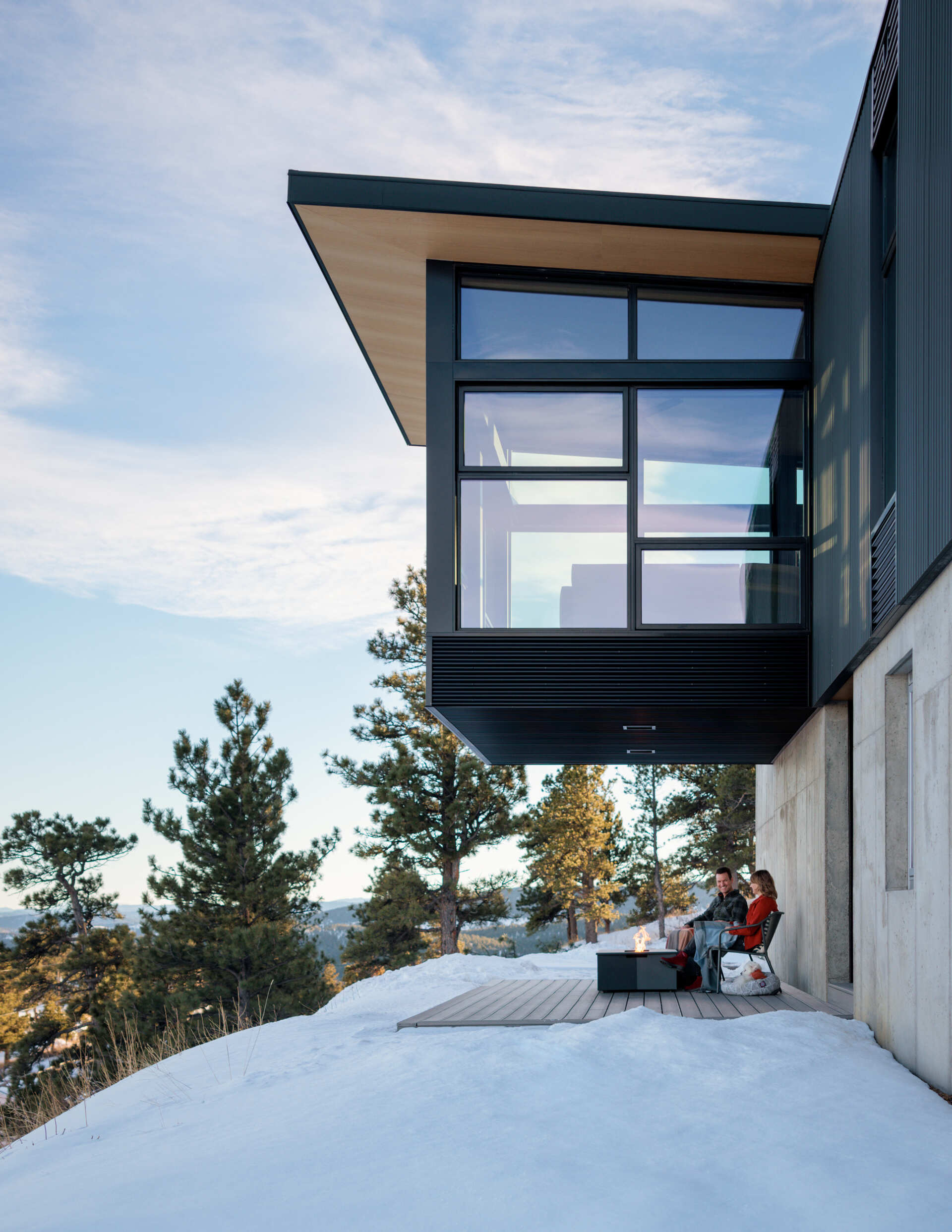 A sheltered entry porch sits beneath the cantilevered living room, creating a welcoming arrival that feels both practical and beautifully framed by the structure.