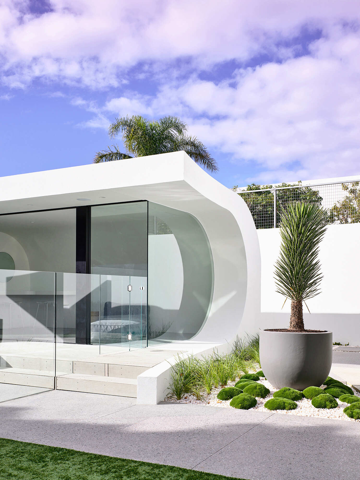 An infinity edge spa and pool sit beside a wave style pool house that offers shade and comfort after long days in the sun.