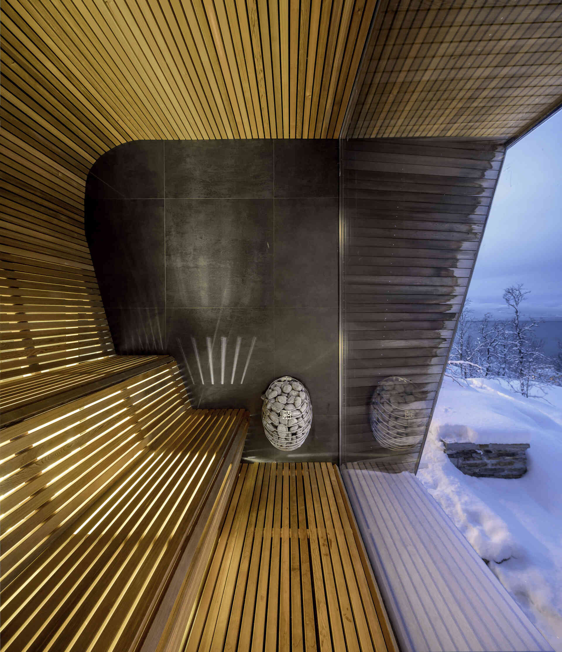 La sauna revestida de cedro cuenta con paredes de vidrio sin marco, lo que ofrece momentos de tranquilidad con vistas al bosque.