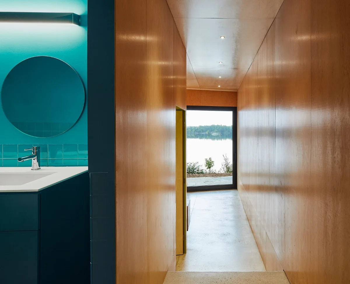 Downstairs, wood-lined bedrooms offer a calm retreat. A turquoise bathroom adds a playful twist, connecting the lower level to the color story above.