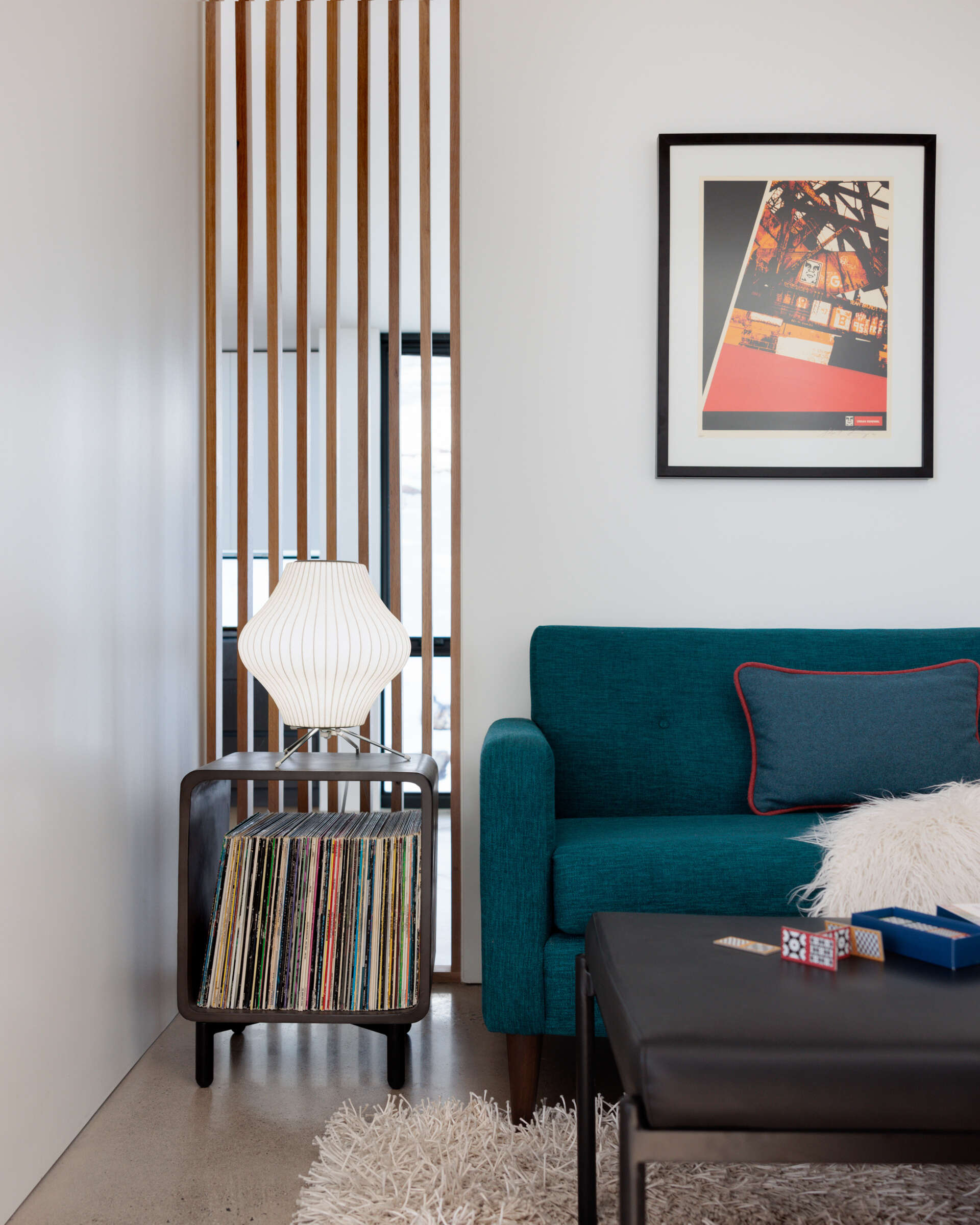 A compact, multipurpose TV room shaped around views, offers comfort without excess, with a wood slat partition helping to keep the room connected to the other interior spaces.