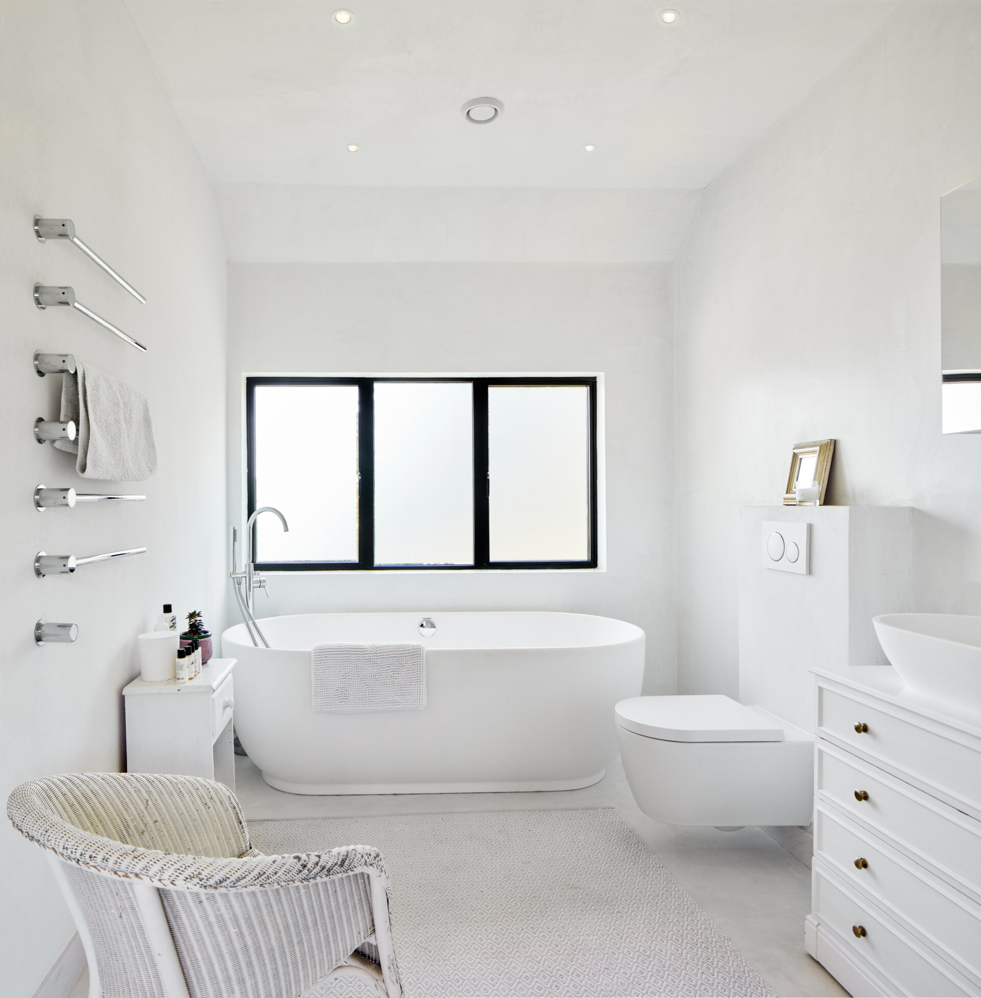 In this bathroom everything is kept crisp and white, so the rooms feel bright and unforced. Minimal black accents give just enough definition without breaking the calm.
