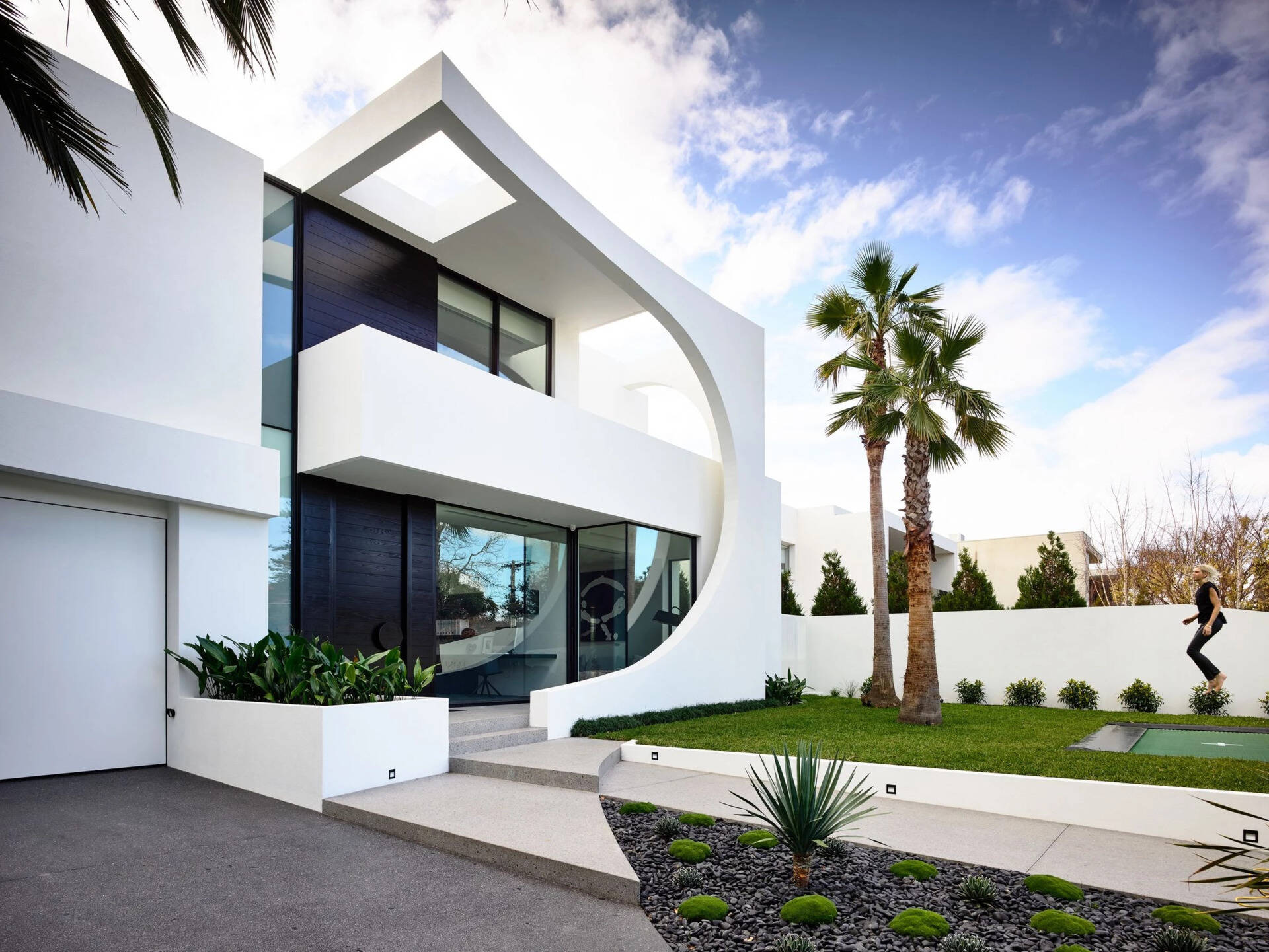 A bold concrete facade with sweeping curves and black Japanese oak detailing that instantly sets the tone for this modern Brighton family home.