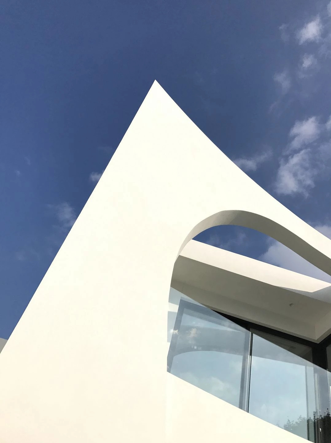 A sculptural exterior defined by confident angles and soft curves that cut through concrete and glass, creating a modern presence that perfectly reflects the lively family inside.