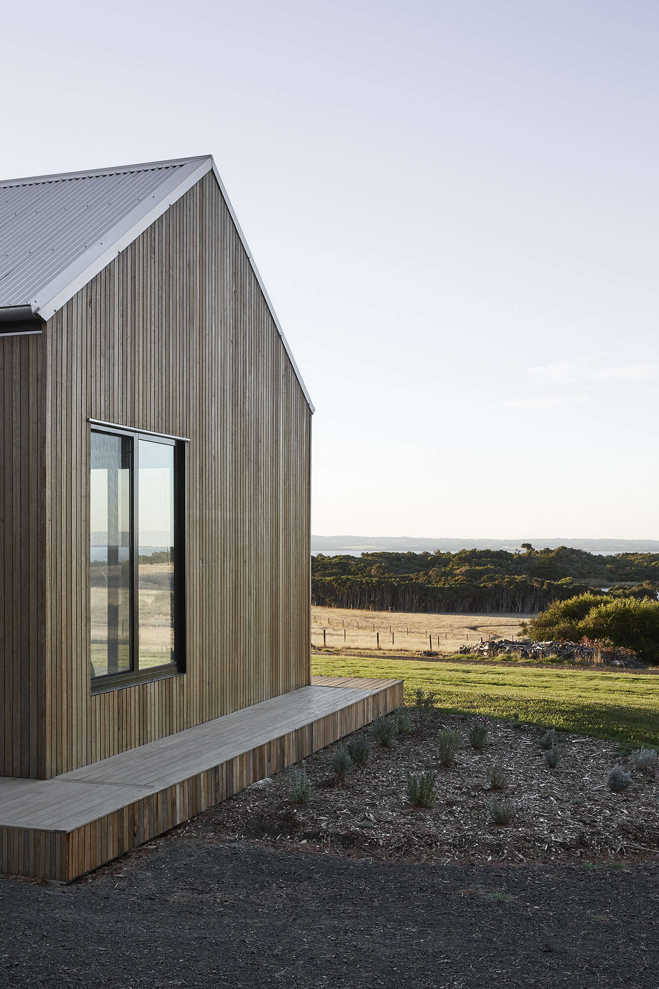 Warm Blackbutt shiplap clads the dual pavilions, giving the home a soft minimal look inspired by the local barn vernacular.