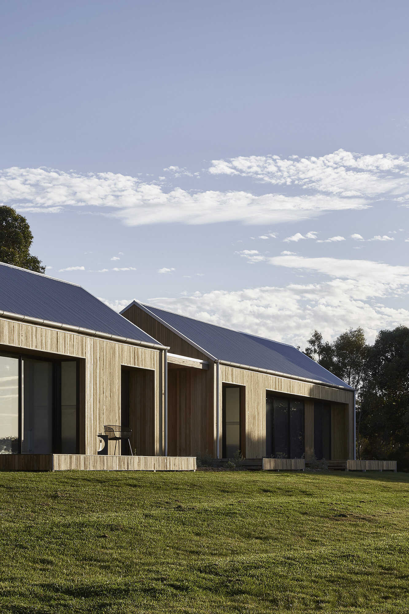 Warm Blackbutt shiplap clads the dual pavilions, giving the home a soft minimal look inspired by the local barn vernacular.