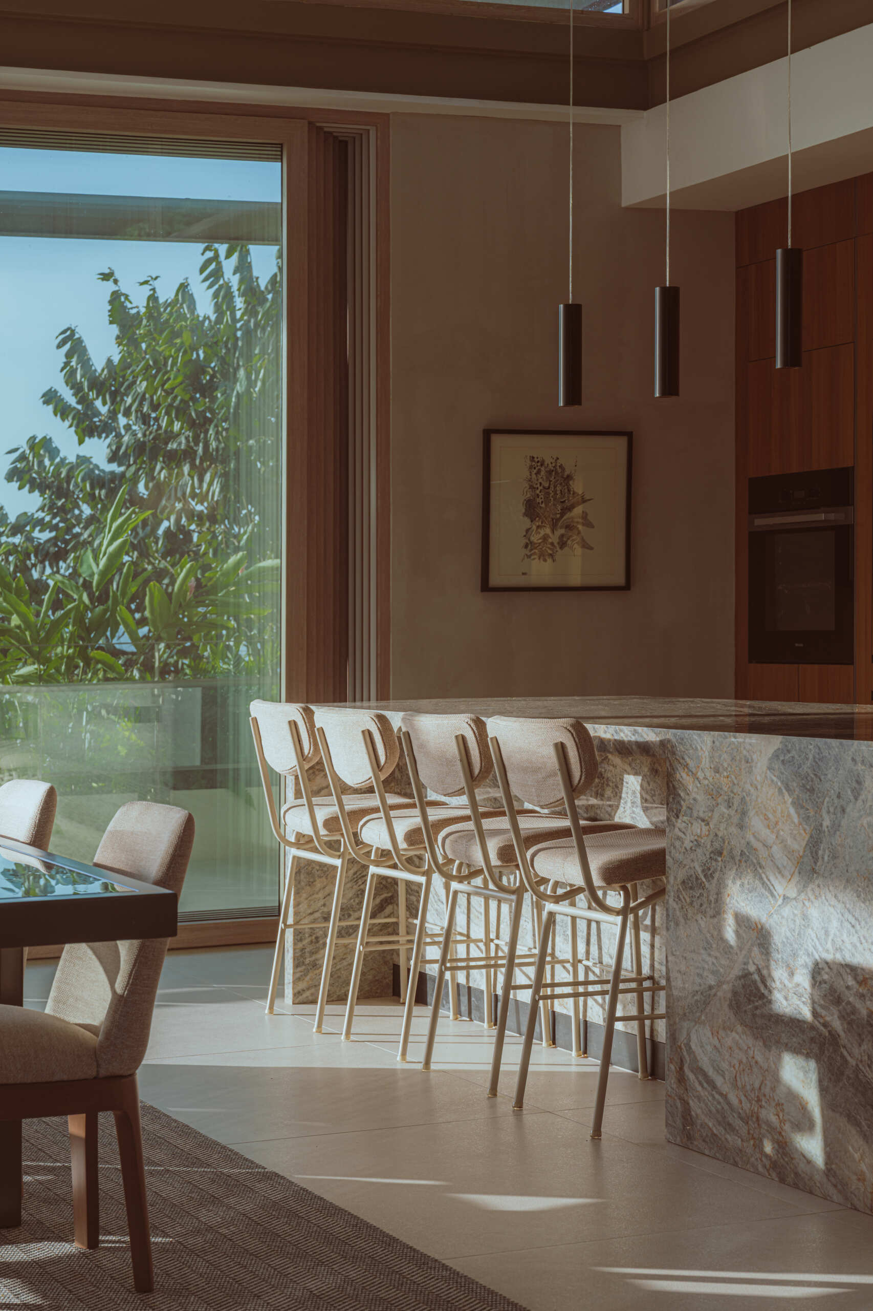 The dining and kitchen areas share the same open platform as the living room, encouraging airflow and clear sightlines. Cross ventilation was a priority throughout the design, and this level shows how shaded openings and long corridors help maintain comfort without mechanical systems.