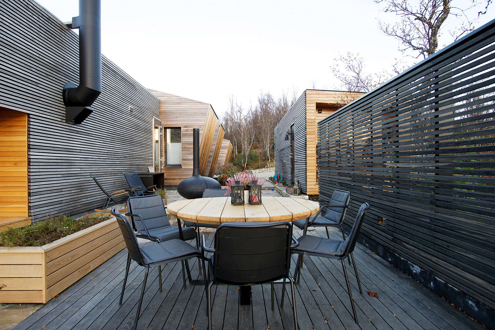 El comedor al aire libre orientado al sur cuenta con una chimenea, perfecto para comidas familiares en climas cálidos.