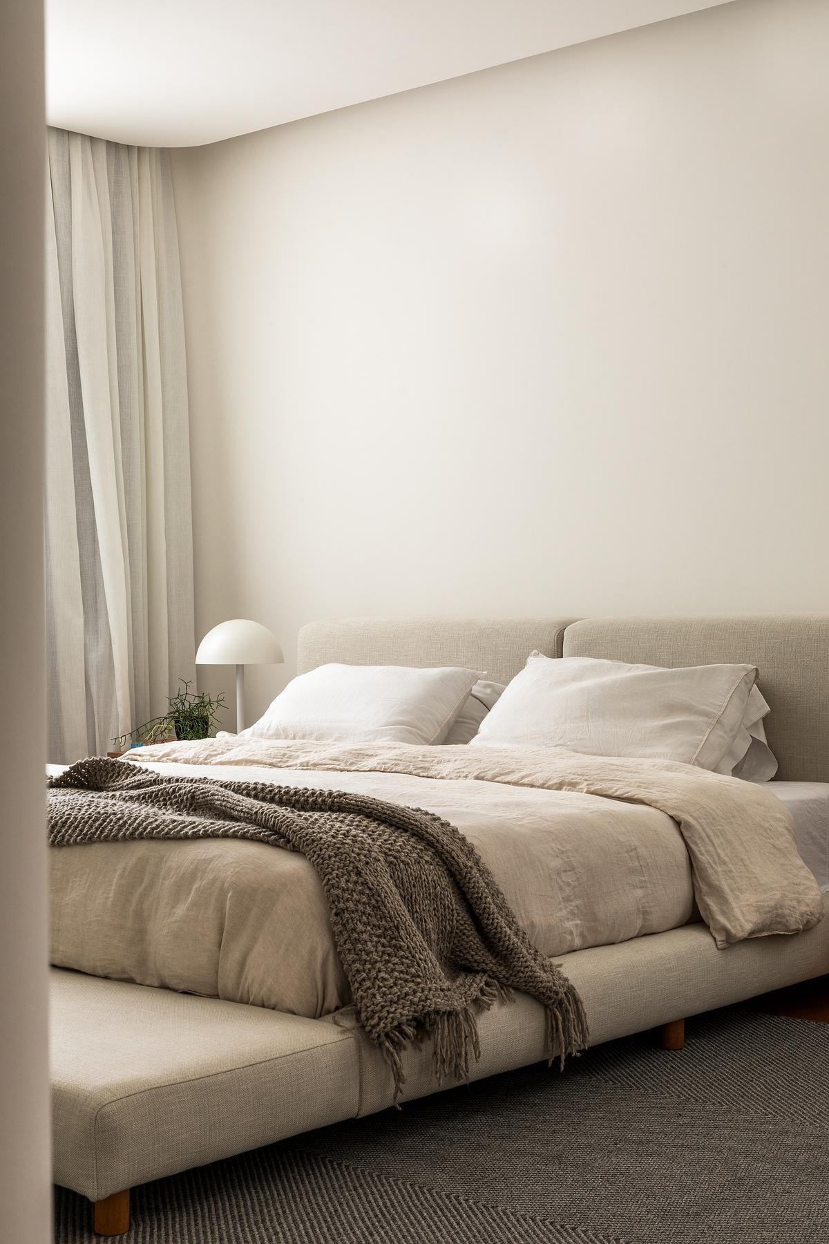 This modern primary suite features the Cuca Armchair by Zanine Caldas and the Lina Bench by Alencar, designed specifically for the homeowners, while soft materials and personal objects build a calm, collected atmosphere.