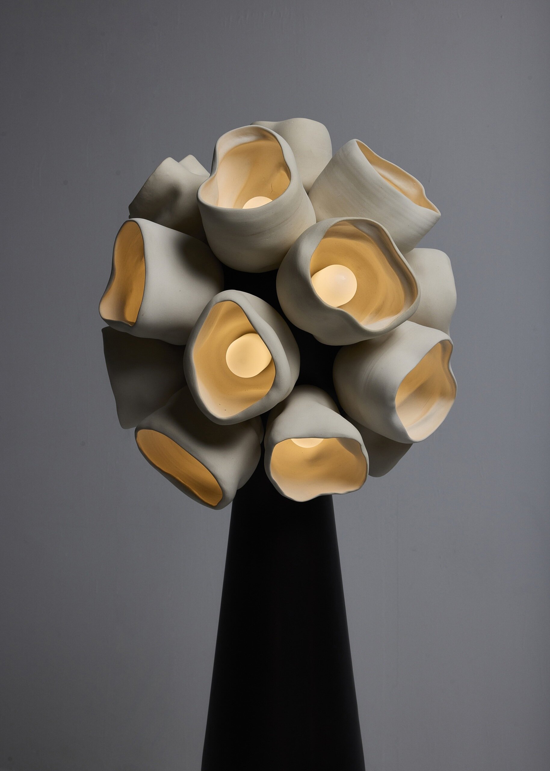 Vessels de Nader Gammas es una colección de iluminación escultórica inspirada en hongos en forma de copa que combina la artesanía cerámica hecha a mano con formas suaves y orgánicas para crear piezas llenas de efectos luminosos que dan una sensación de vida en un espacio.