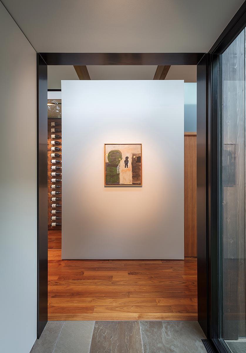 A simple hallway that ends with a single framed artwork for a gallery like moment.