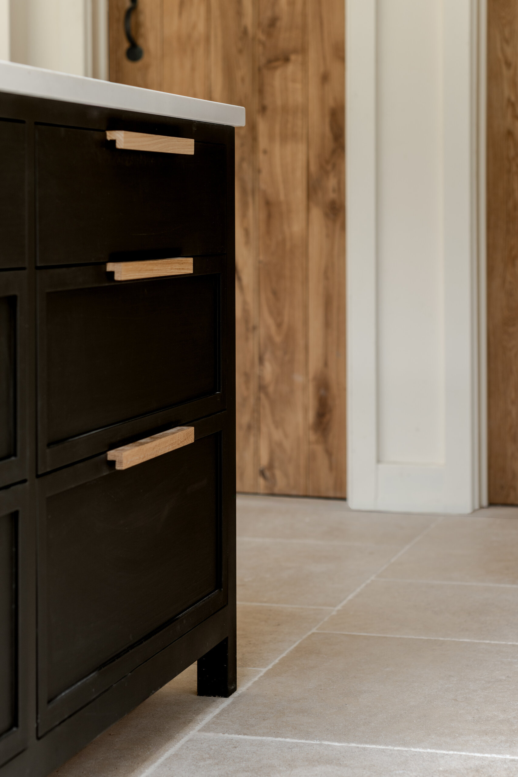 The kitchen sits within the open plan arrangement, using the new glazing and steel details to add clarity and simplicity while keeping the palette restrained. The dark kitchen cabinets complement the window frames and offer contrast to the light interior, while a skylight adds natural light.