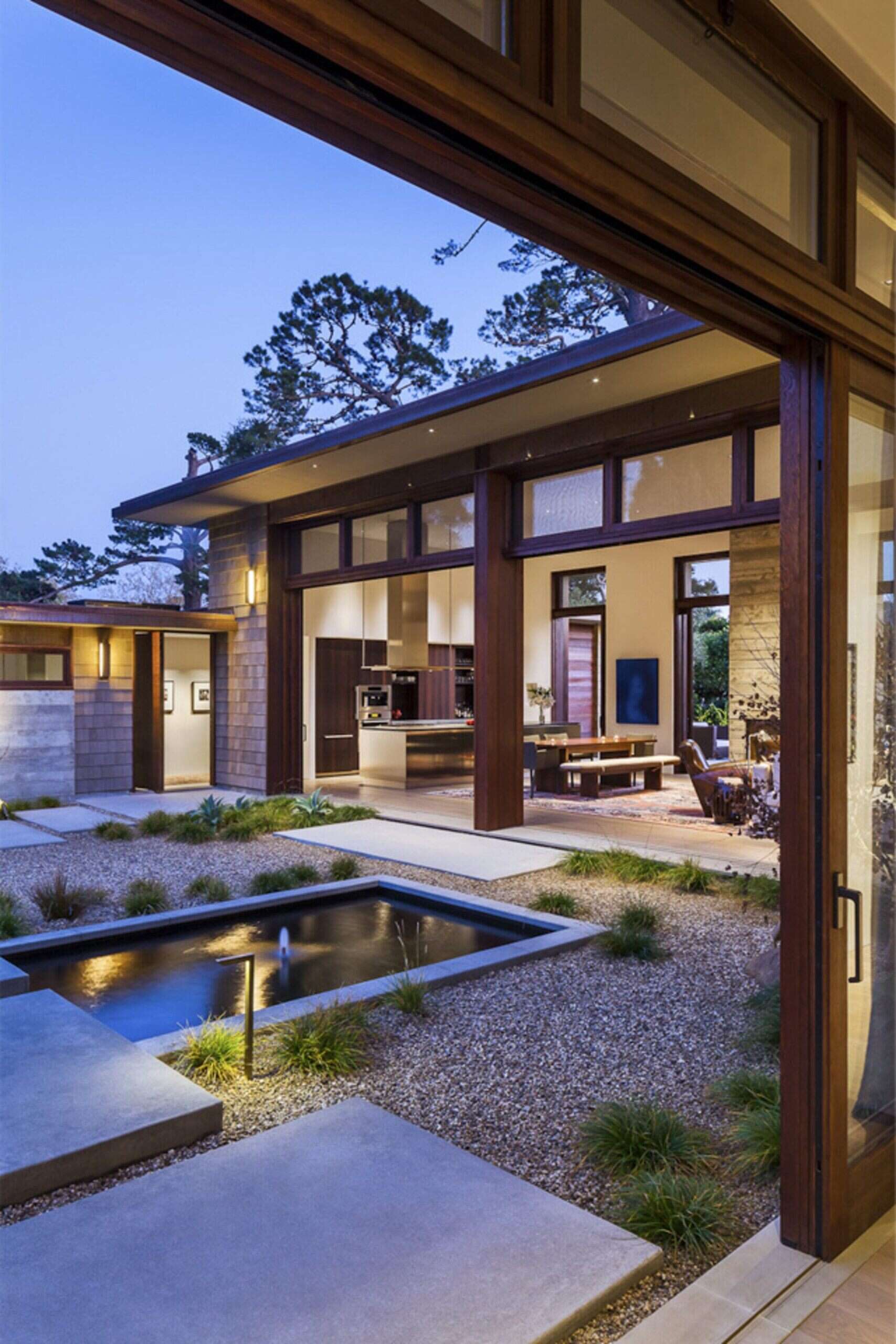 A serene Montecito courtyard with water, stone, and greenery creates a tranquil welcome to this modern home.