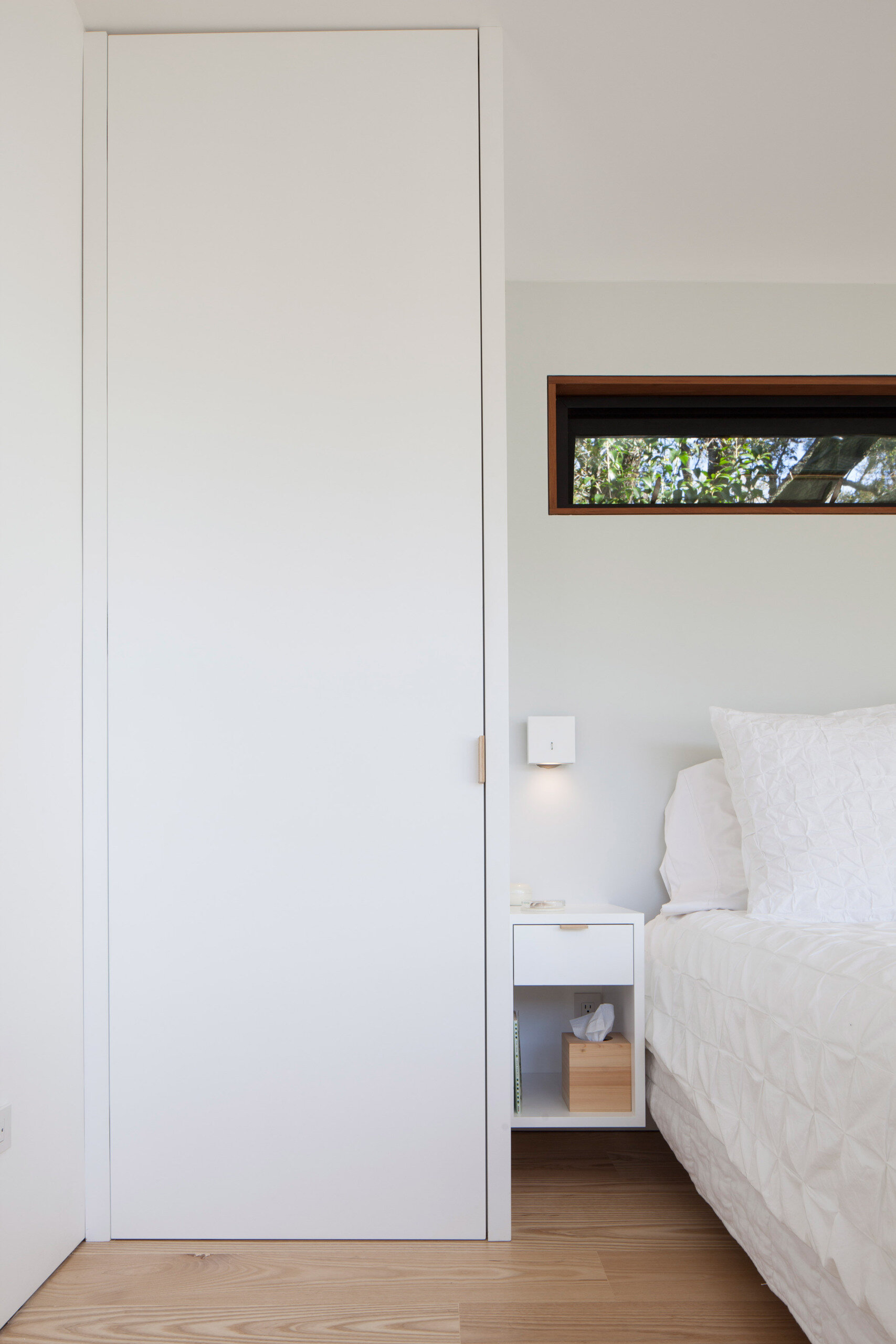 The primary bedroom suite combines large windows, built-in storage, and a bright ensuite with porcelain tiles for a serene retreat.