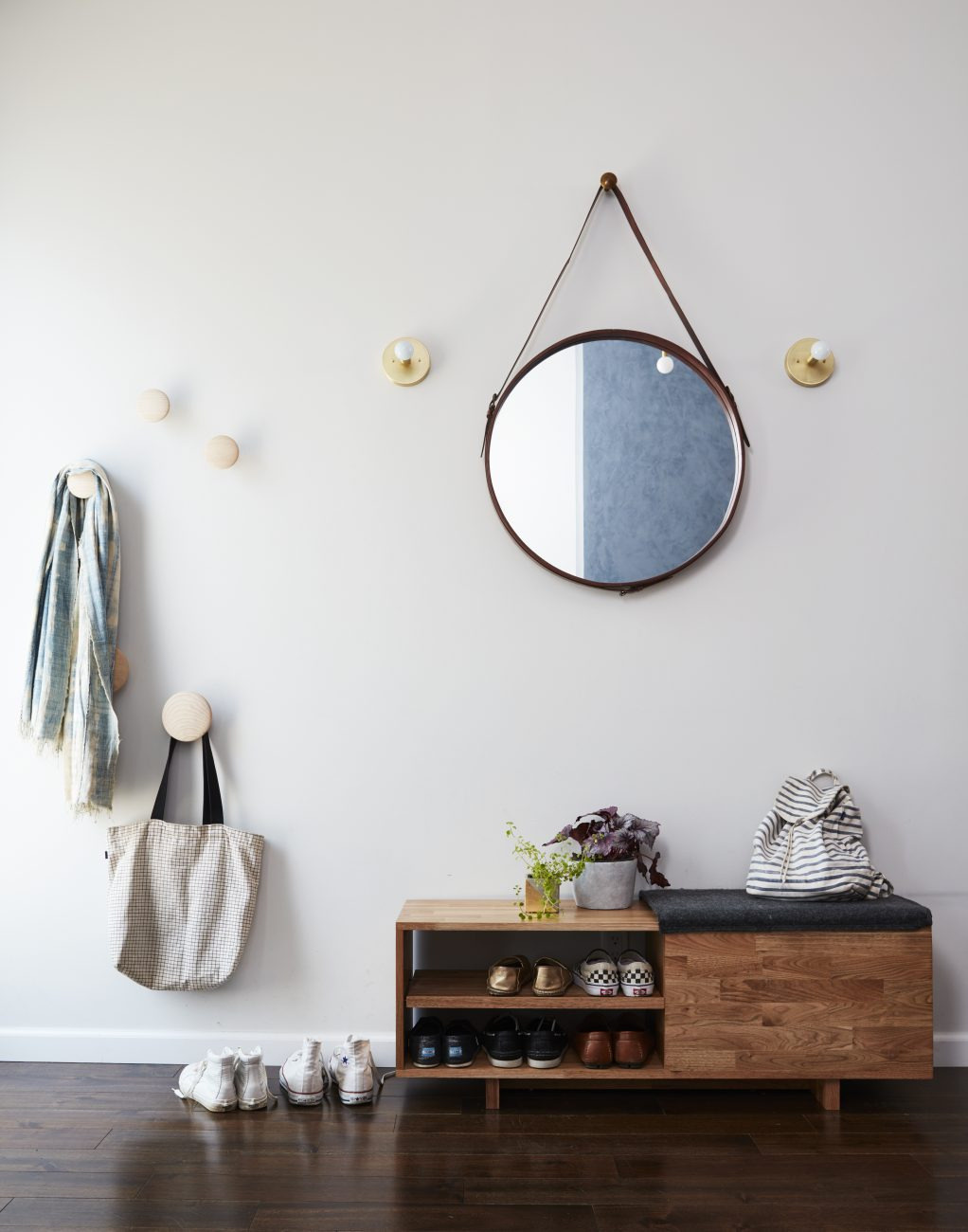 A calm and functional entryway with a round mirror, soft sconces, and smart storage designed for everyday family life.