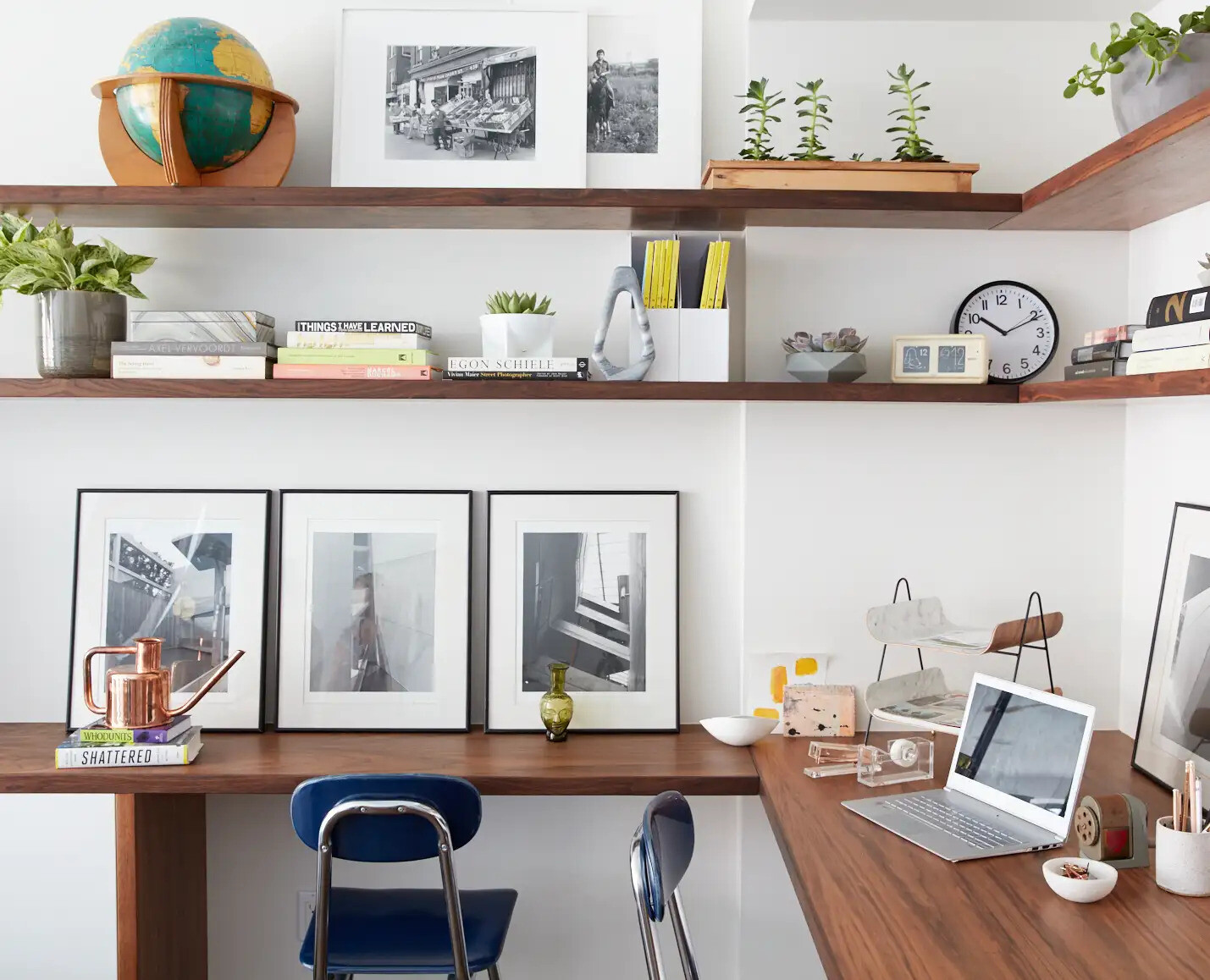 Wraparound wood shelving and a shared desk create a practical home office designed for two.