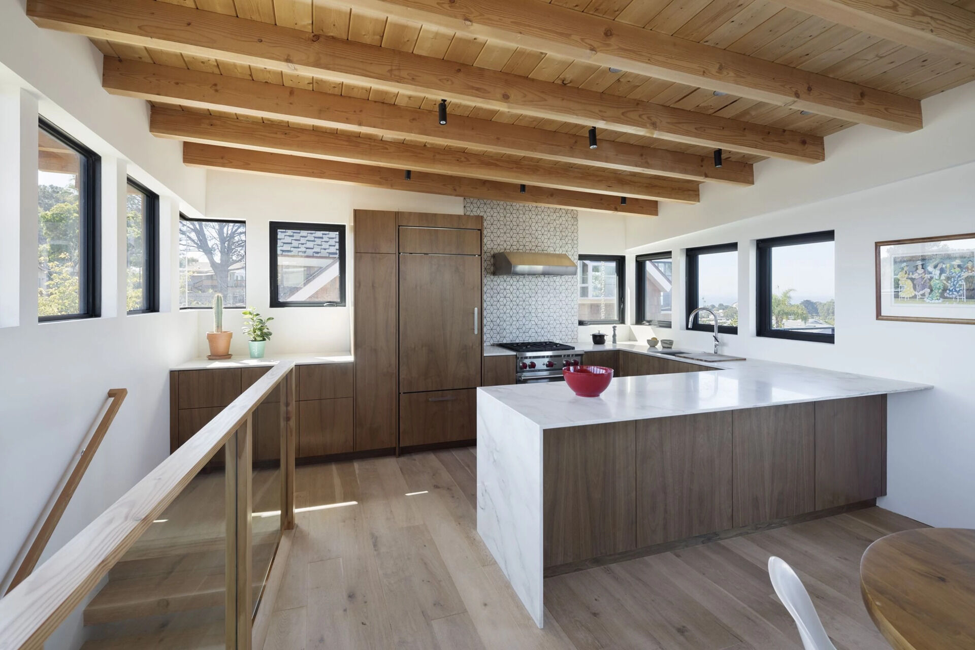 Sunlit interiors are framed by dark metal windows that contrast beautifully with warm materials throughout the home.