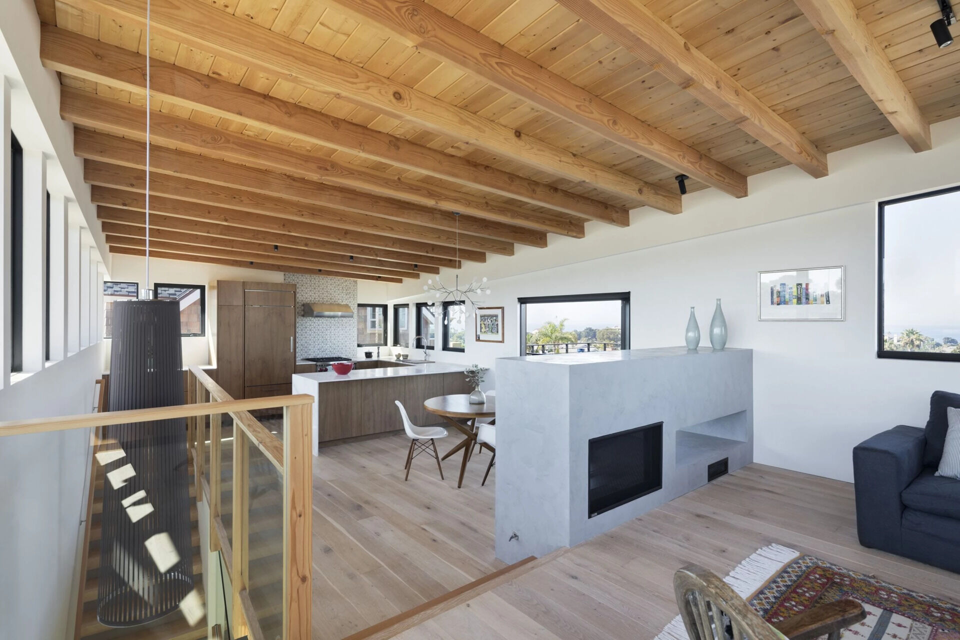 A double sided low fireplace connects the dining and living areas while maintaining an open and relaxed layout.