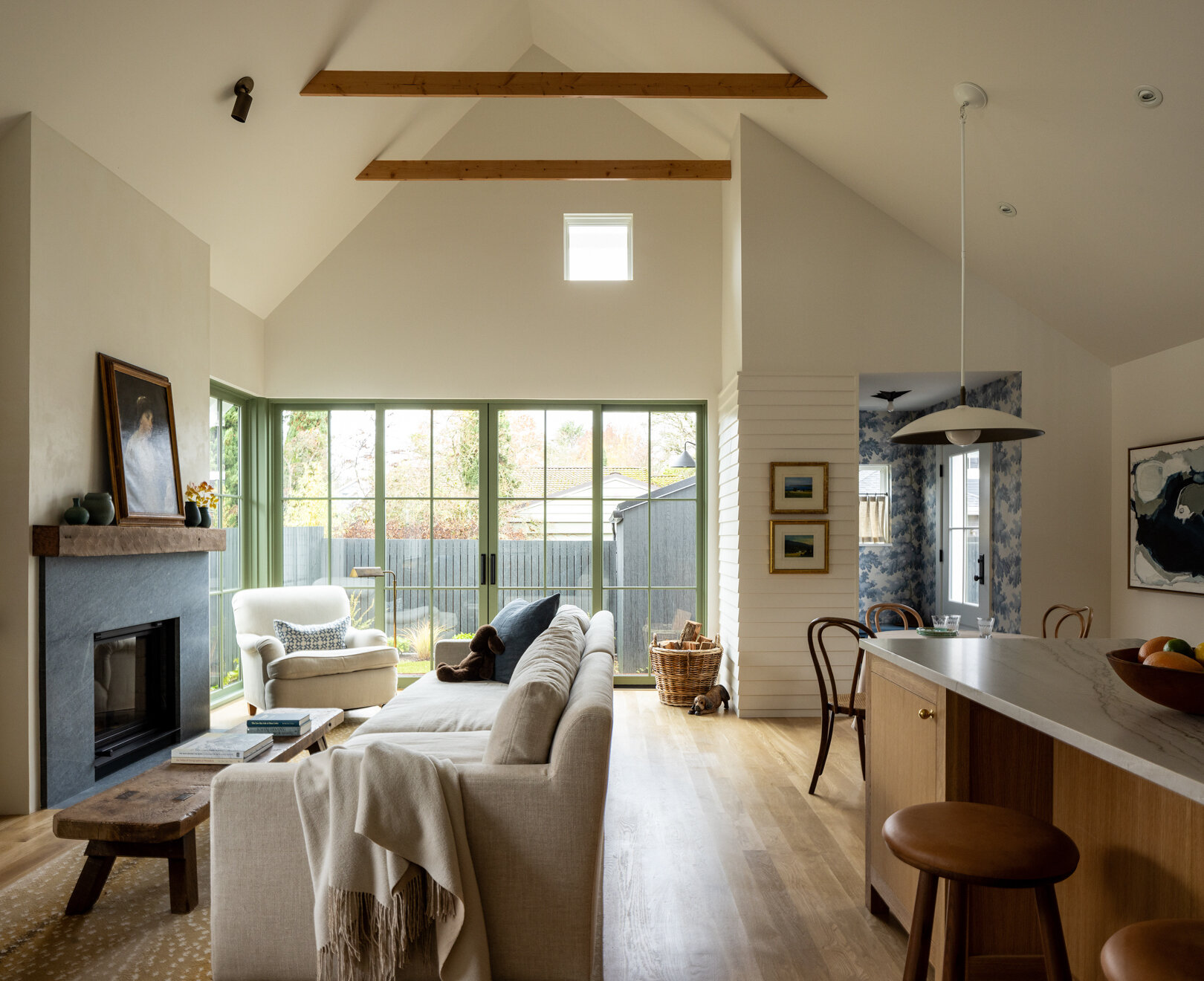 La sala de estar abovedada es el corazón de la casa y está diseñada para reuniones informales. Las traviesas de madera expuestas añaden calidez al techo, mientras que una chimenea central añade una sensación nostálgica de solidez a la habitación.