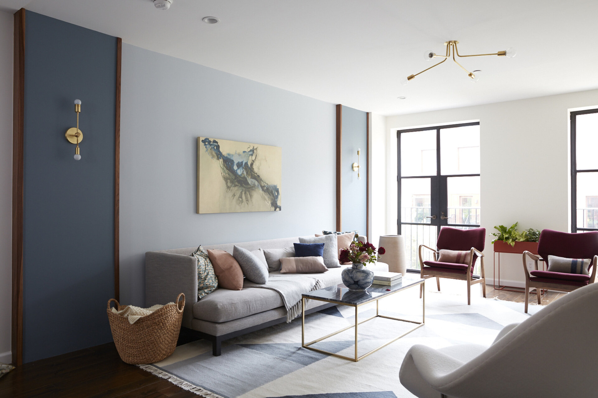 Steel and glass French doors open to a Juliet balcony, bringing light and openness to this living room.