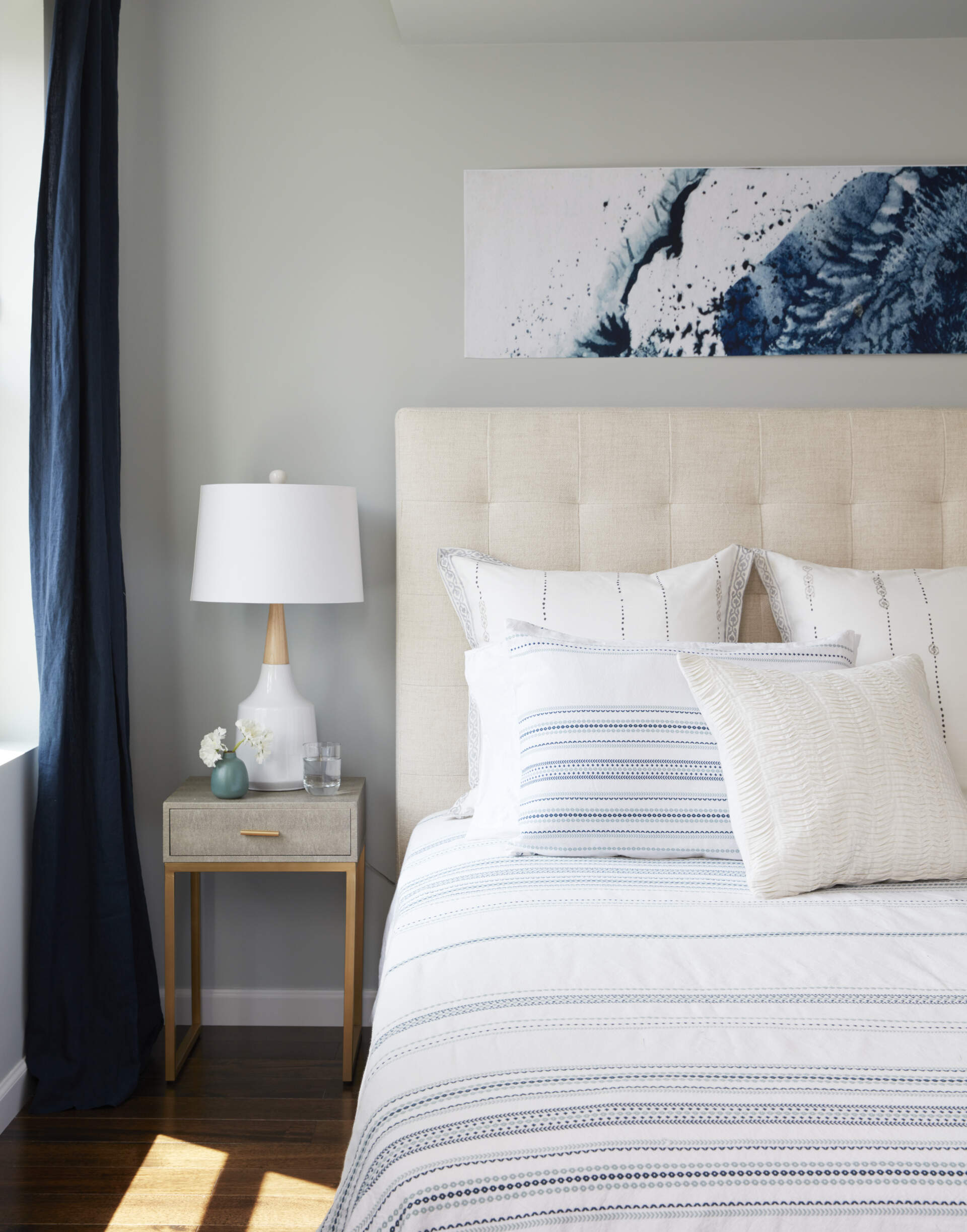 Neutral tones and deep blue accents shape a calm primary bedroom with rooftop access and city views.