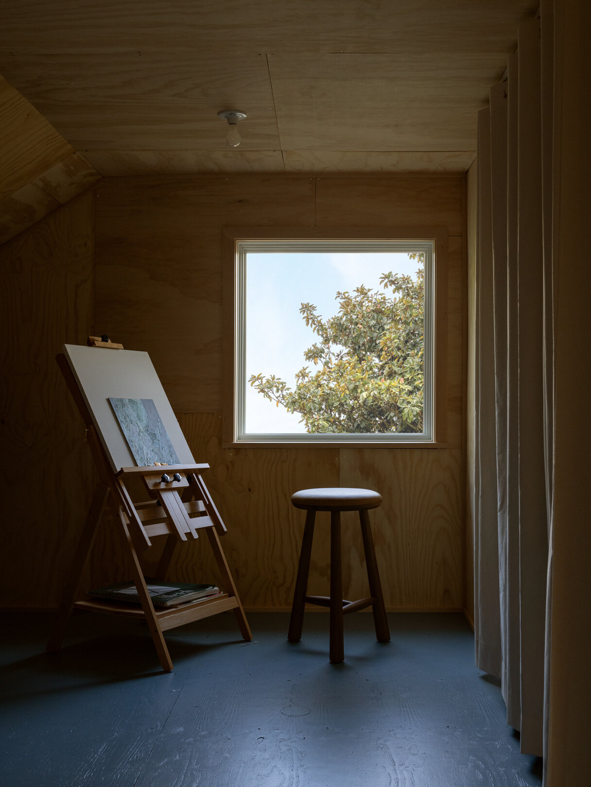 El loft alberga un pequeño estudio de pintura, diseñado como un refugio para la creatividad. Aunque de tamaño modesto, se beneficia de la luz natural de las buhardillas y de una separación silenciosa del piso principal, lo que proporciona un espacio útil que mejora la funcionalidad general de la casa.
