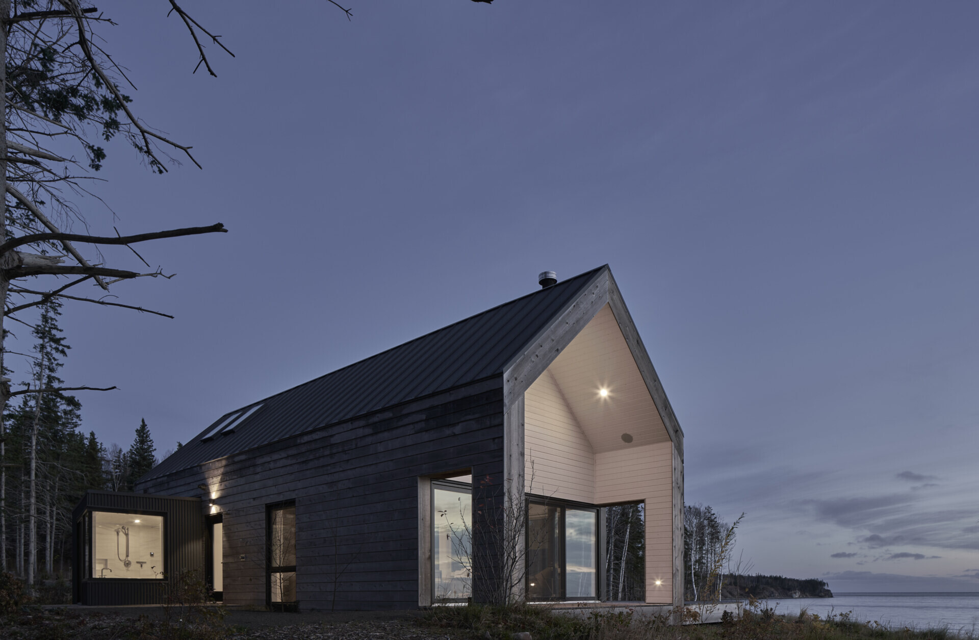 Una colección de cinco cabañas prefabricadas de madera en la costa, diseñadas para la vida al aire libre y la hospitalidad.