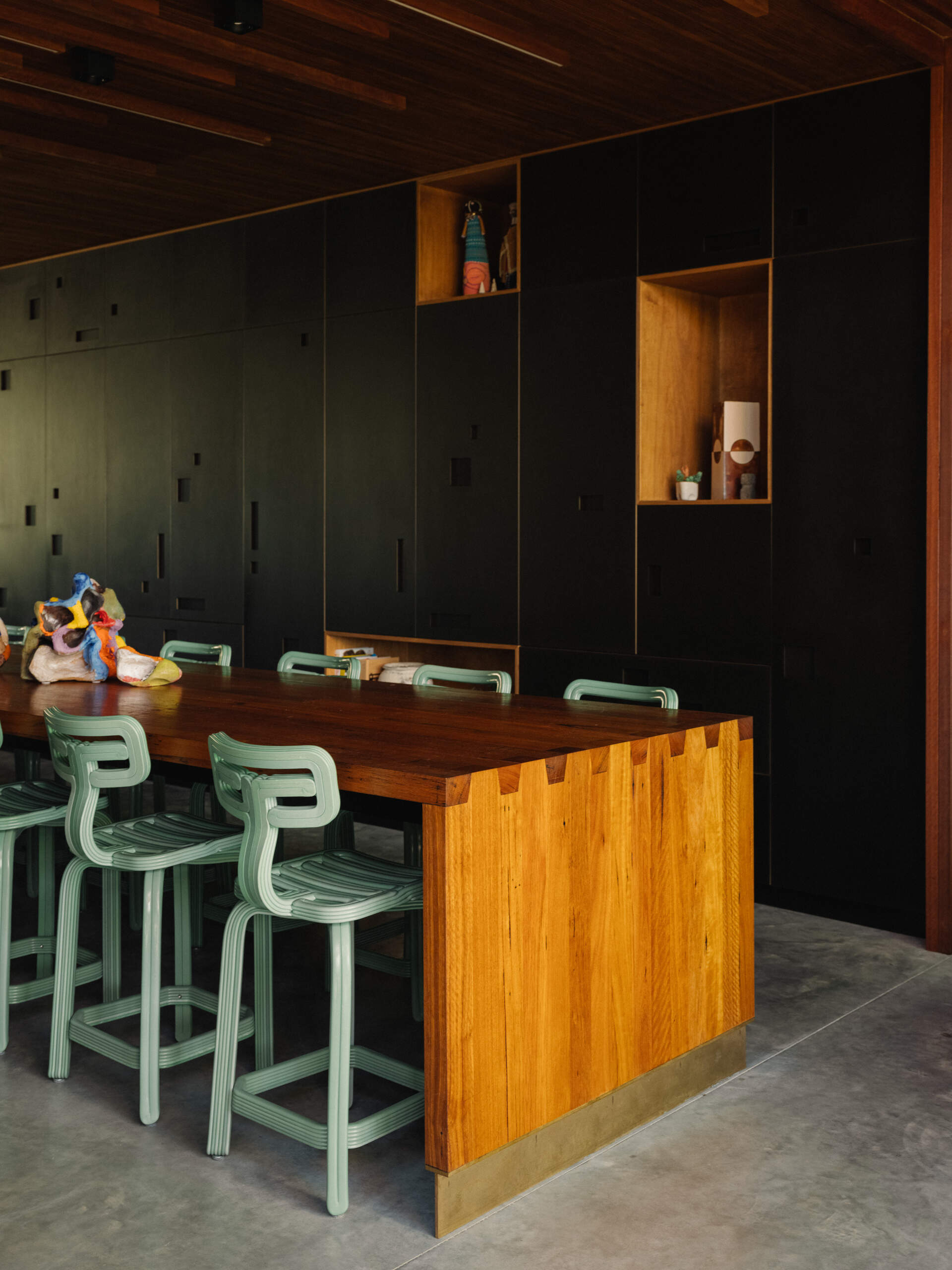 Nearby, the expansive dining space connects directly with the kitchen. Dappled light and airflow move through without barriers. 