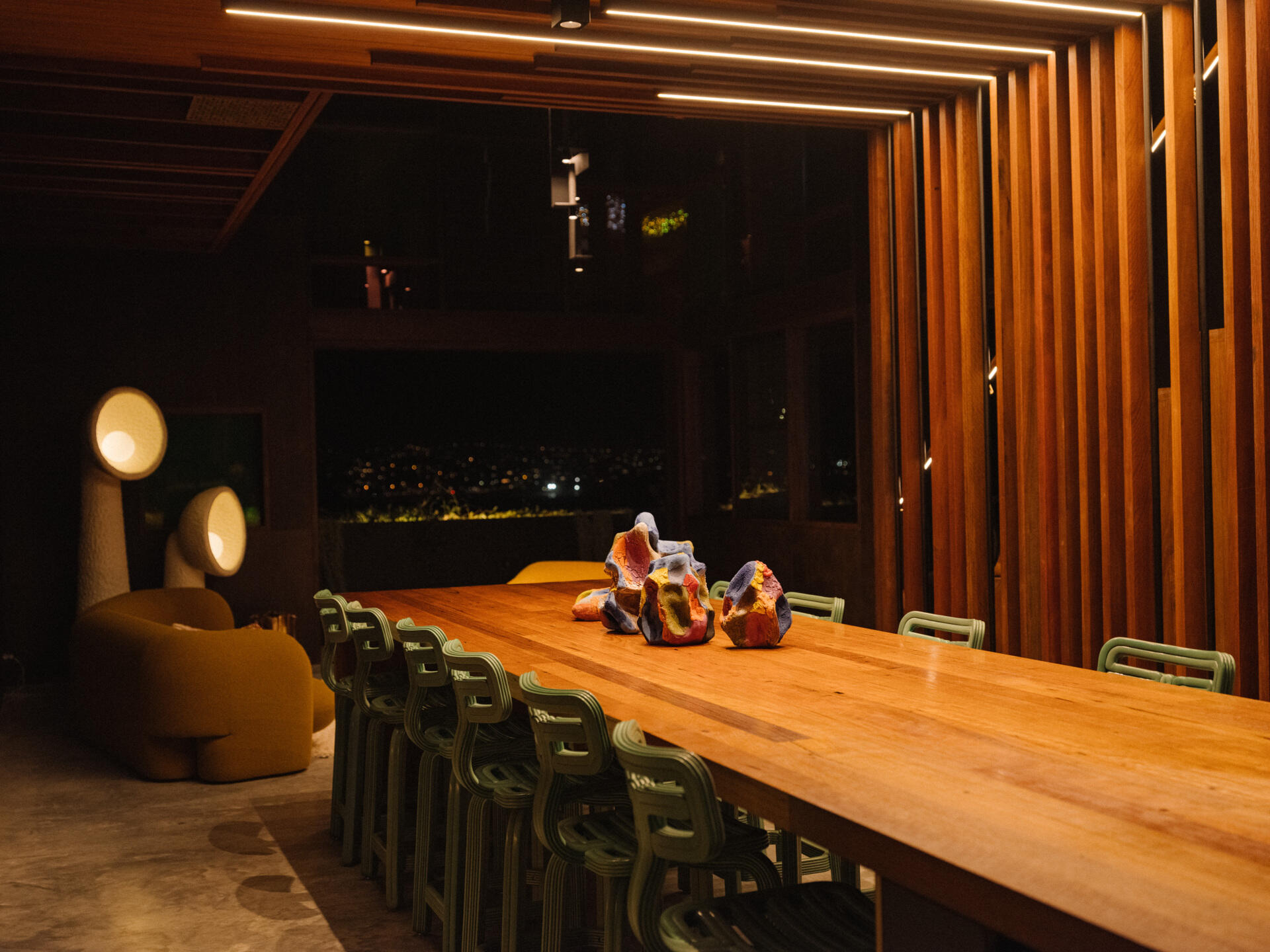 Nearby, the expansive dining space connects directly with the kitchen. Dappled light and airflow move through without barriers. 
