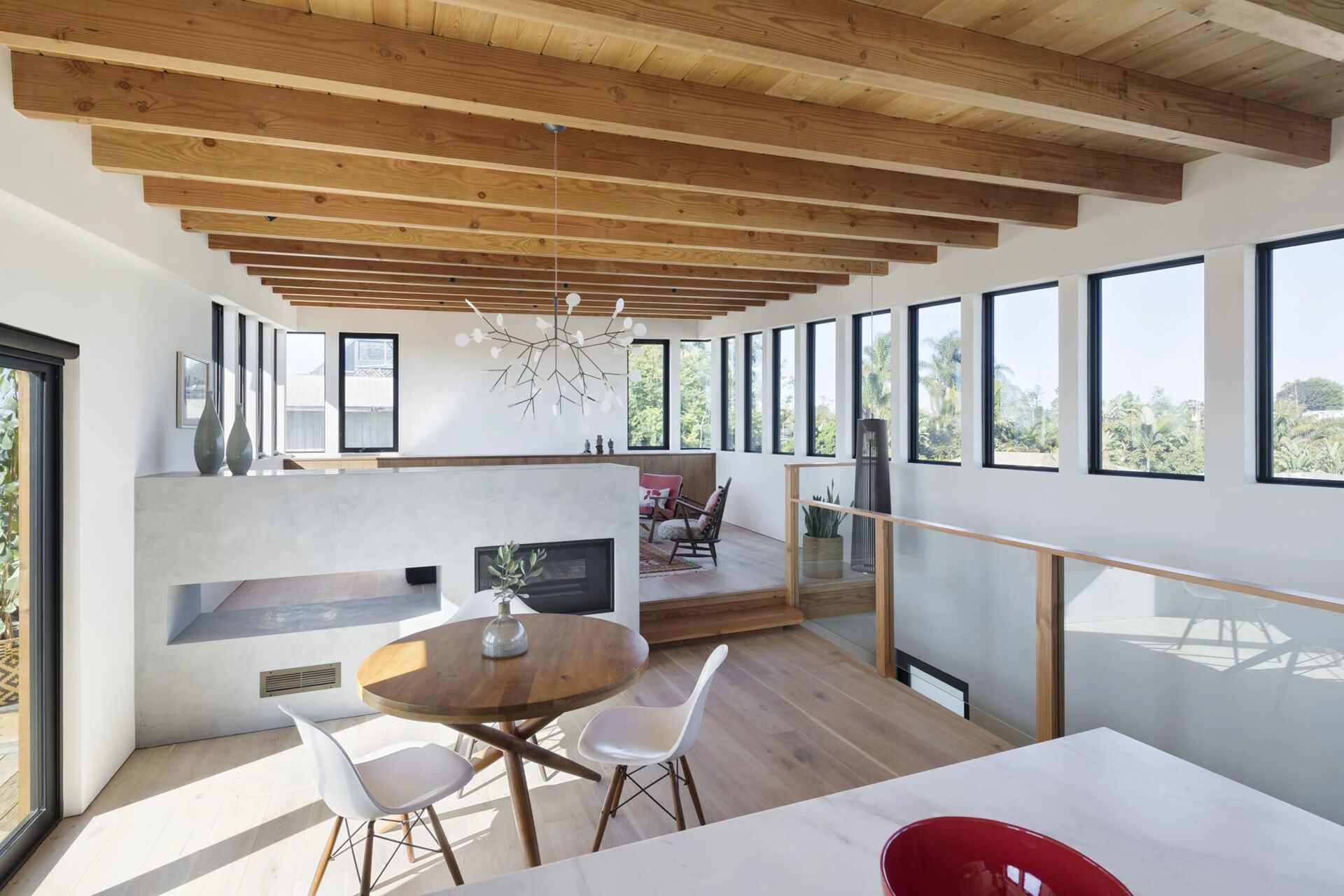 A double sided low fireplace connects the dining and living areas while maintaining an open and relaxed layout.