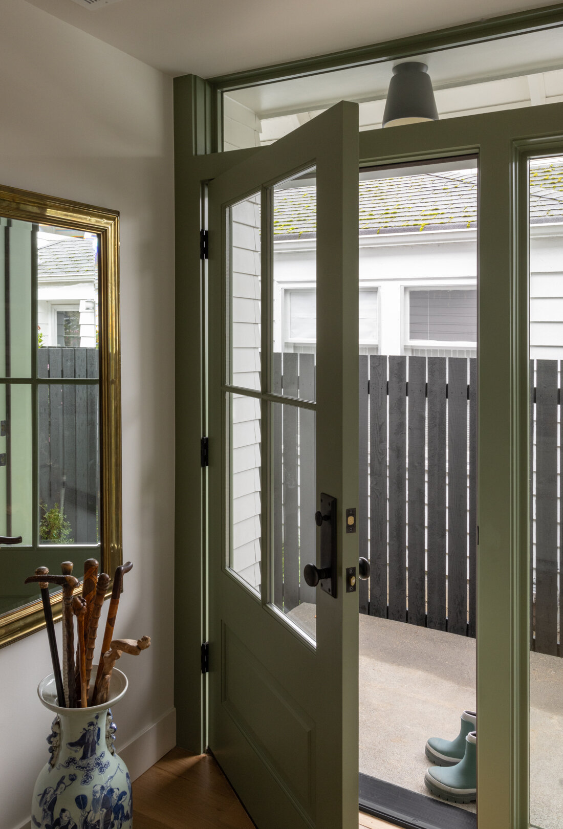 La entrada marca inmediatamente el tono de la combinación de encanto tradicional y artesanía moderna de la casa. Una suave puerta verde le da la bienvenida al interior y sus paneles de vidrio aportan luz natural al espacio.