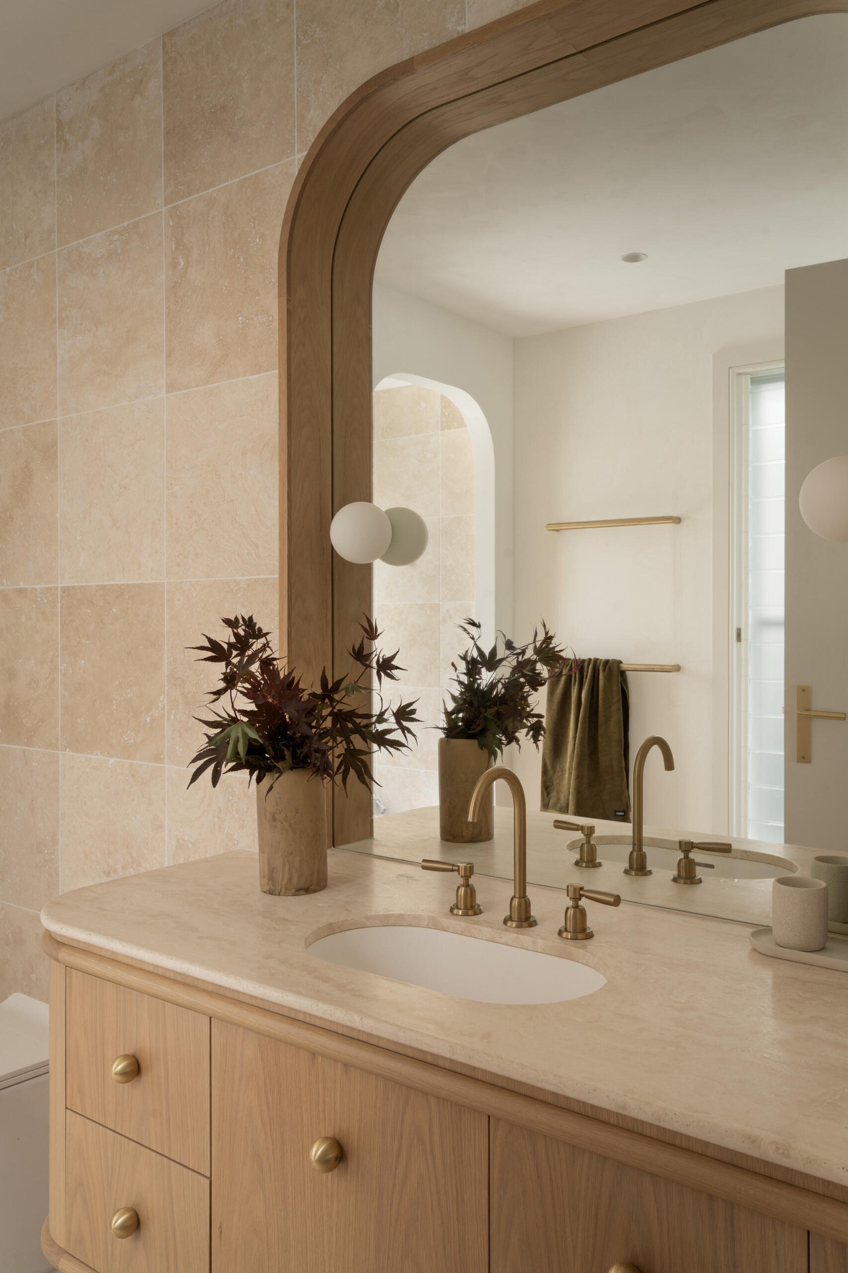 Modern guest bathroom with curves and Travertine details.