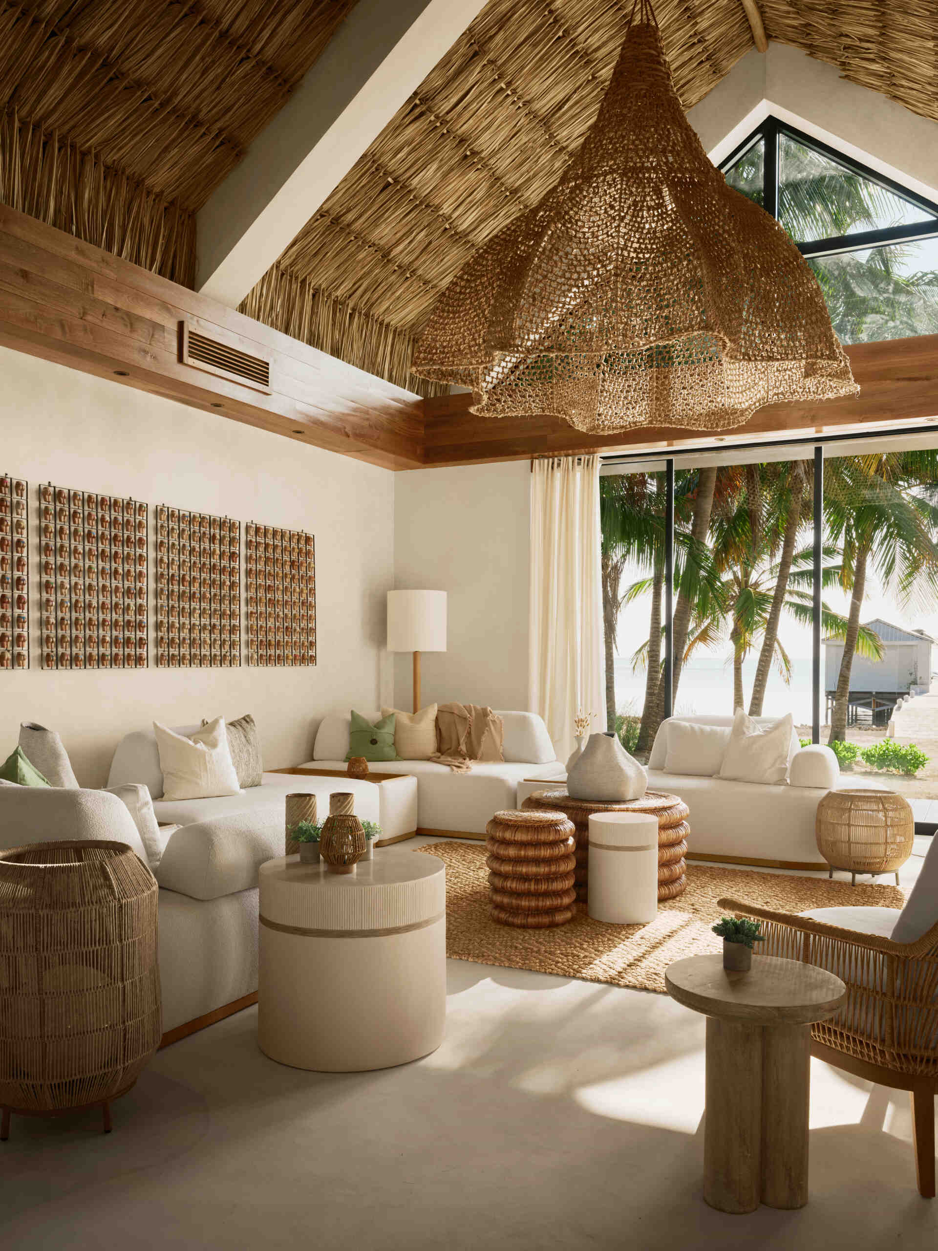 The living room was designed to dissolve the boundary between inside and outside. Large pocketing doors slide fully open, allowing ocean breezes to pass through the space and connect it directly to the pool and patios.