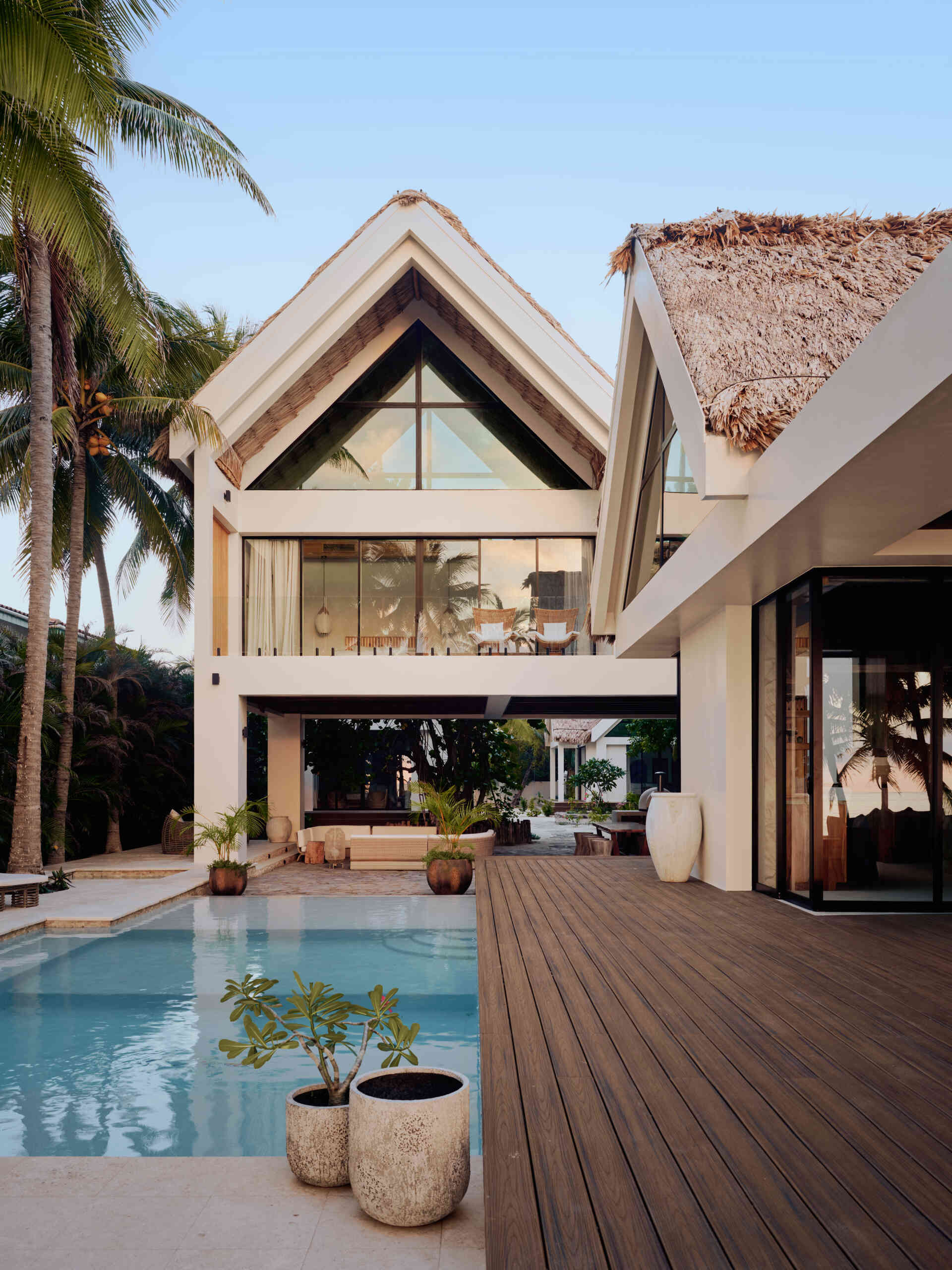 The pool anchors the main living areas and acts as a visual and social connector between the structures. It sits just beyond the living room, reinforcing the idea that outdoor spaces are part of everyday life. Movement between swimming, dining, and lounging happens without separation, keeping everyone within view.