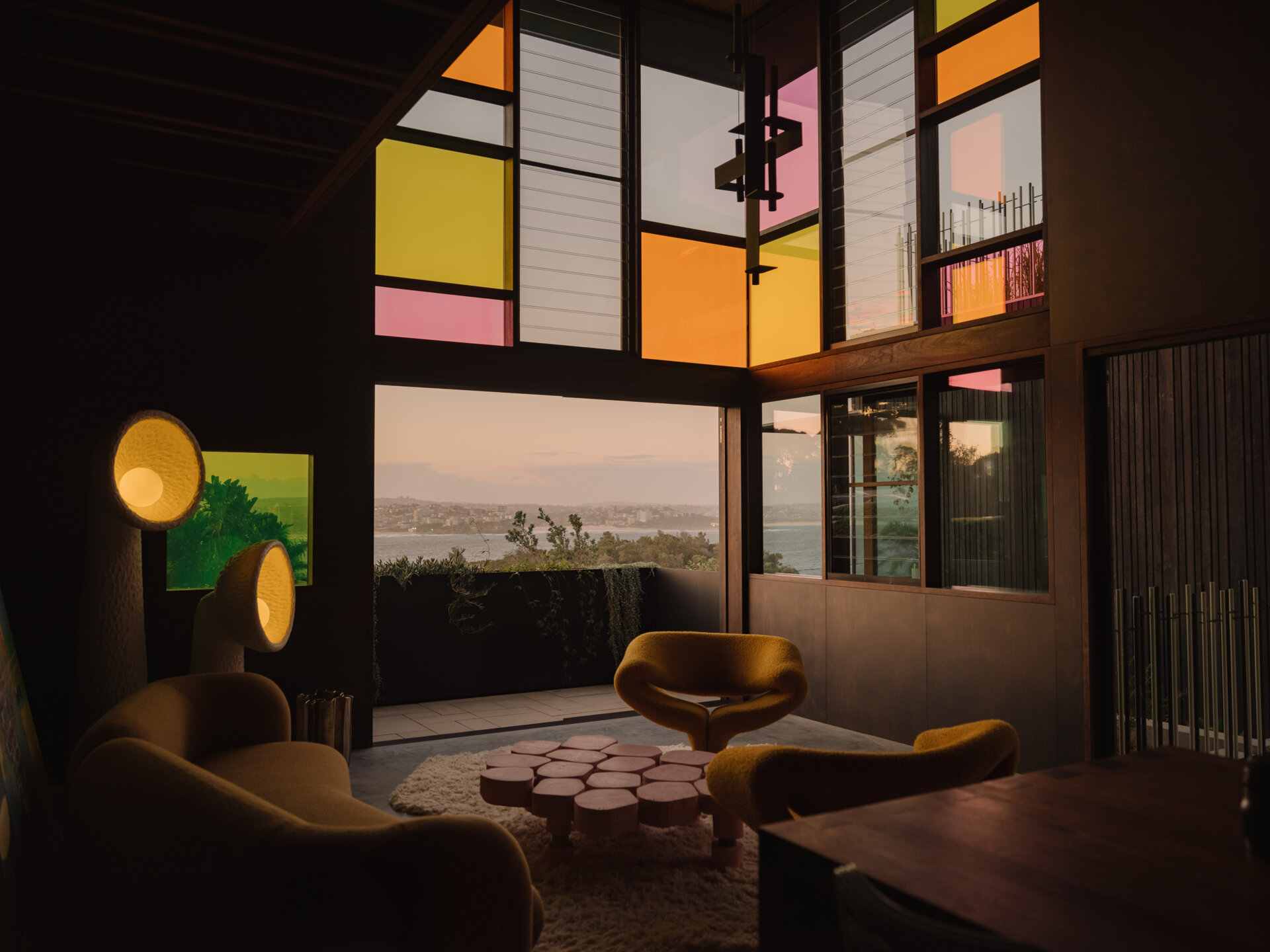 Stained glass panels in the living room fragment coastal views and create moving patterns of light.