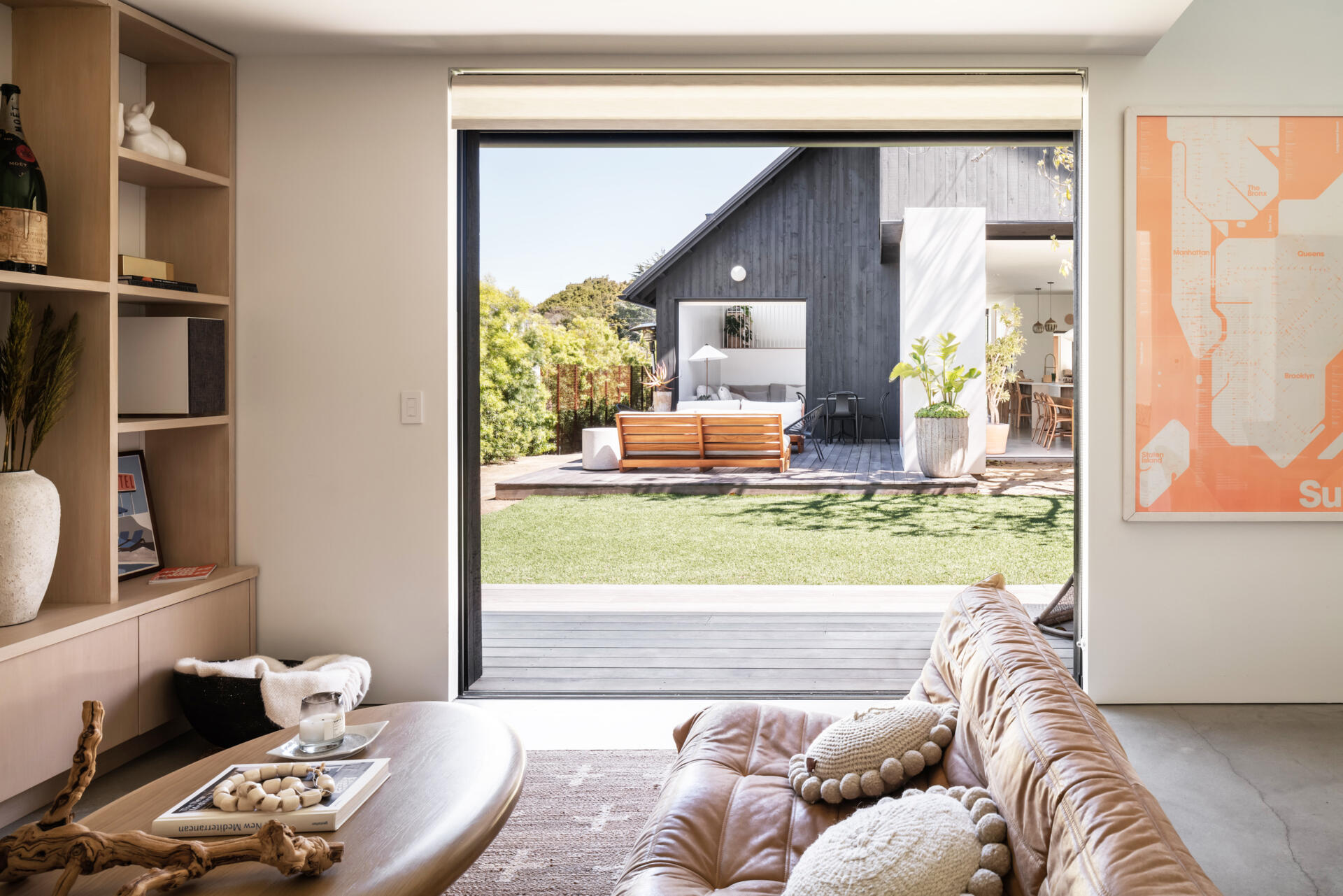 Inside this modern ADU, the material palette mirrors the main house, creating visual continuity across the site. The living and dining areas are compact yet complete, offering independence without feeling isolated, while the kitchenette lines the wall.