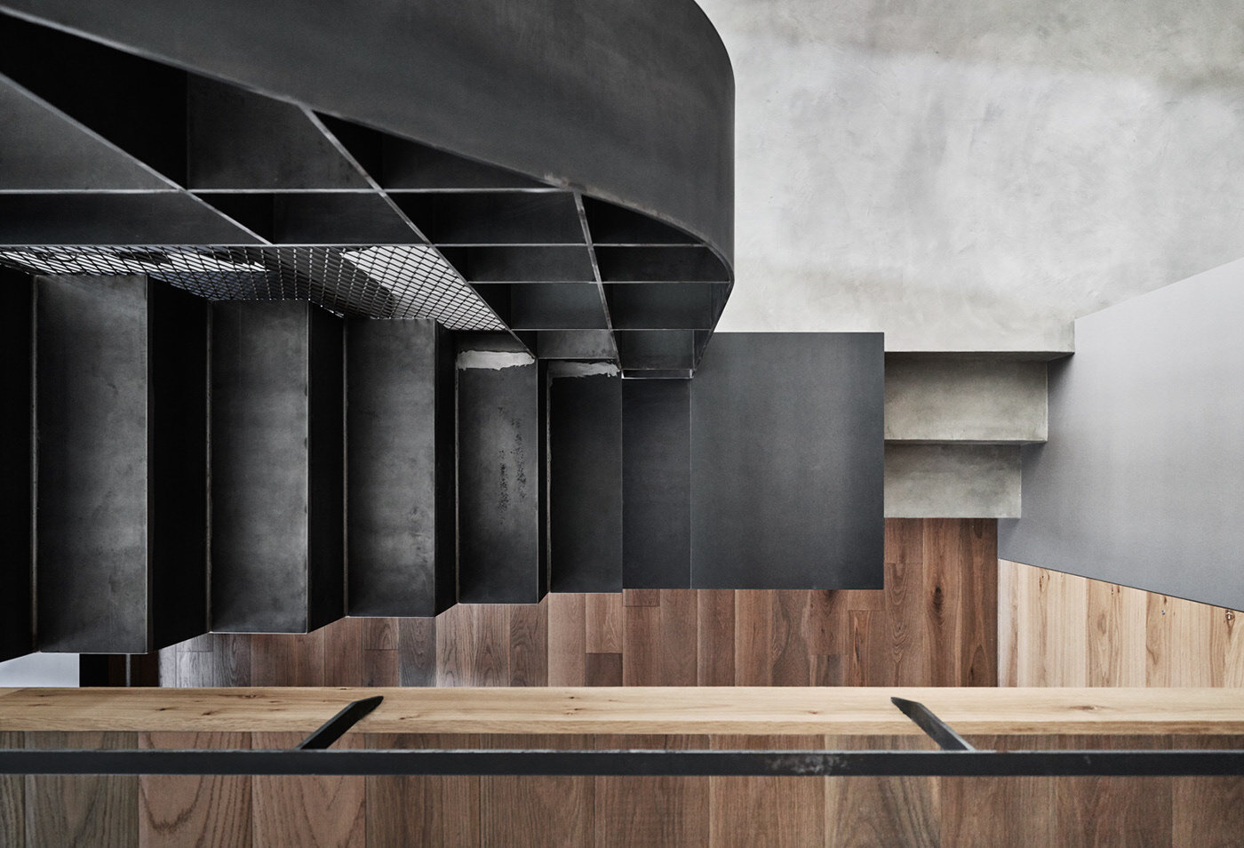 Steel stairs in a tiny apartment connect three levels while enhancing visual flow and spatial efficiency.