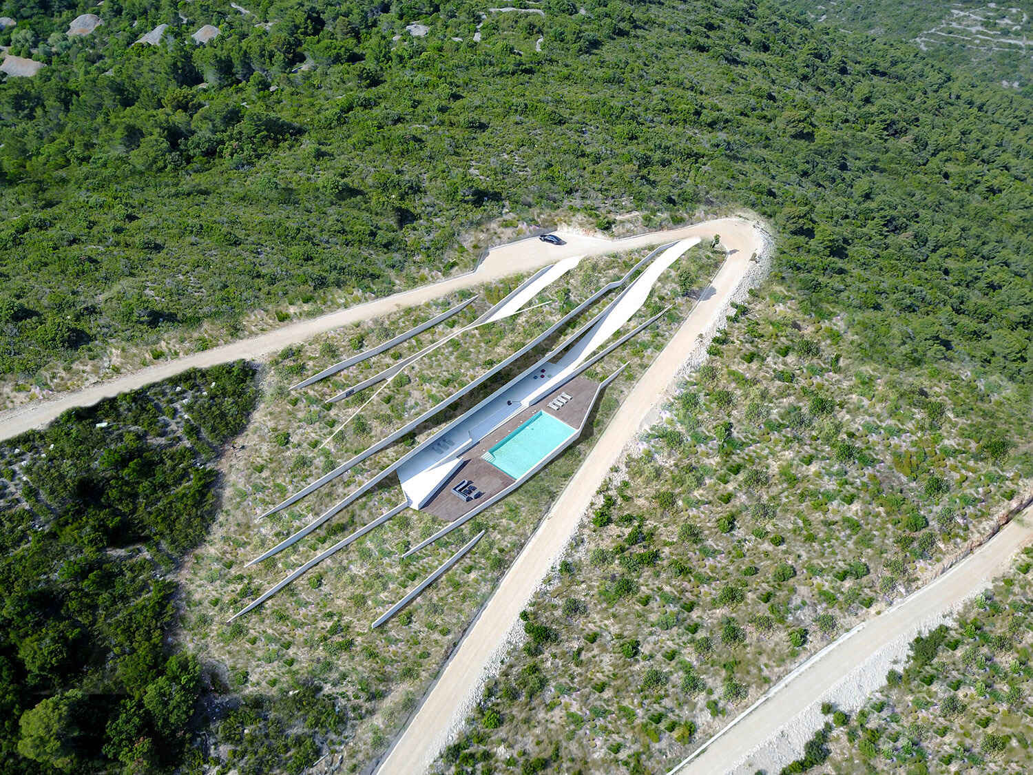 Construida directamente en la empinada ladera de la isla de Vis, esta moderna residencia de hormigón está diseñada para ubicarse en el paisaje, en lugar de estar encima de él.
